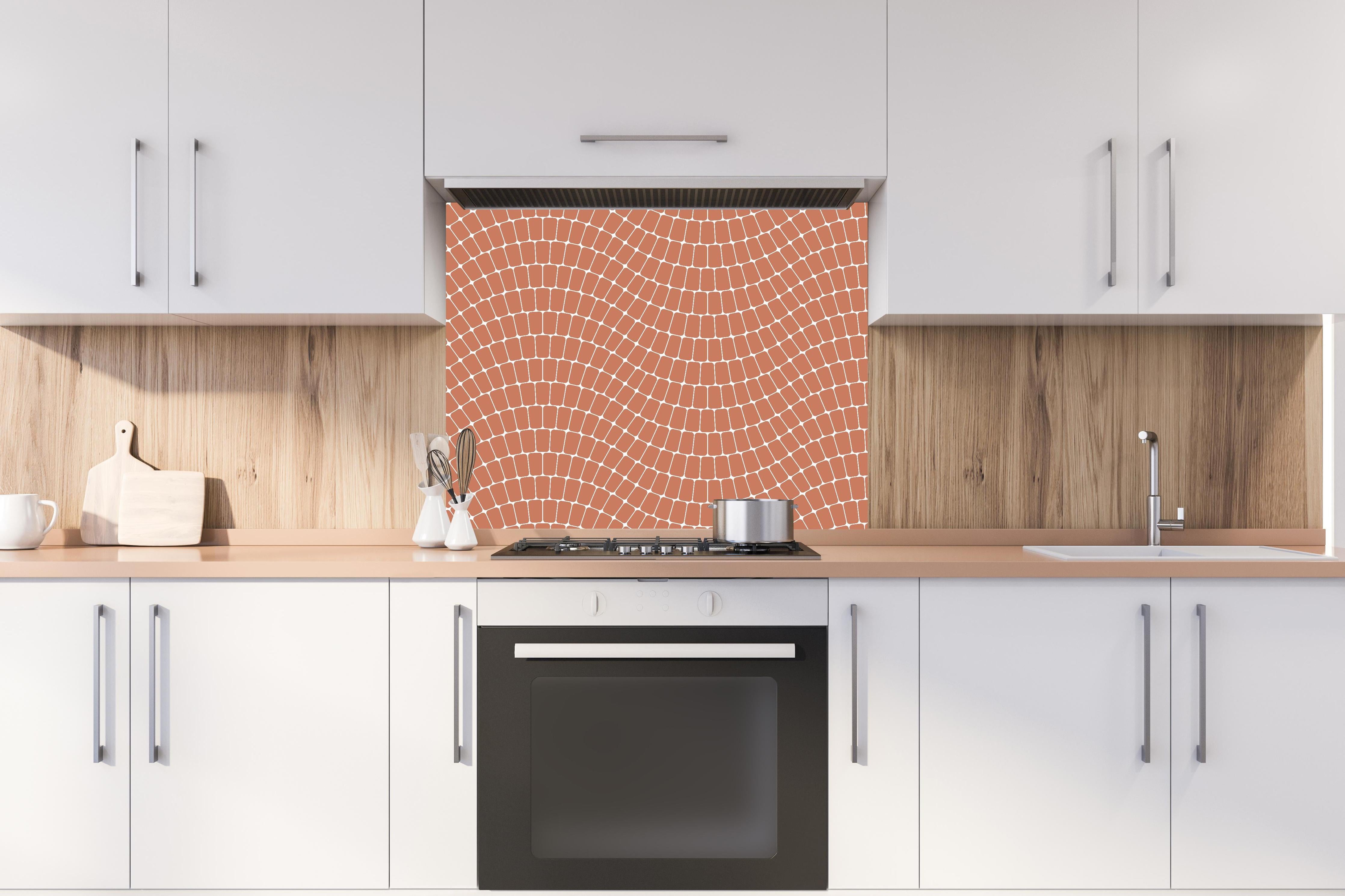 Spritzschutz - Onde Sinuoso Terracotta hinter einem Cerankochfeld zwischen Holz-Kochutensilien