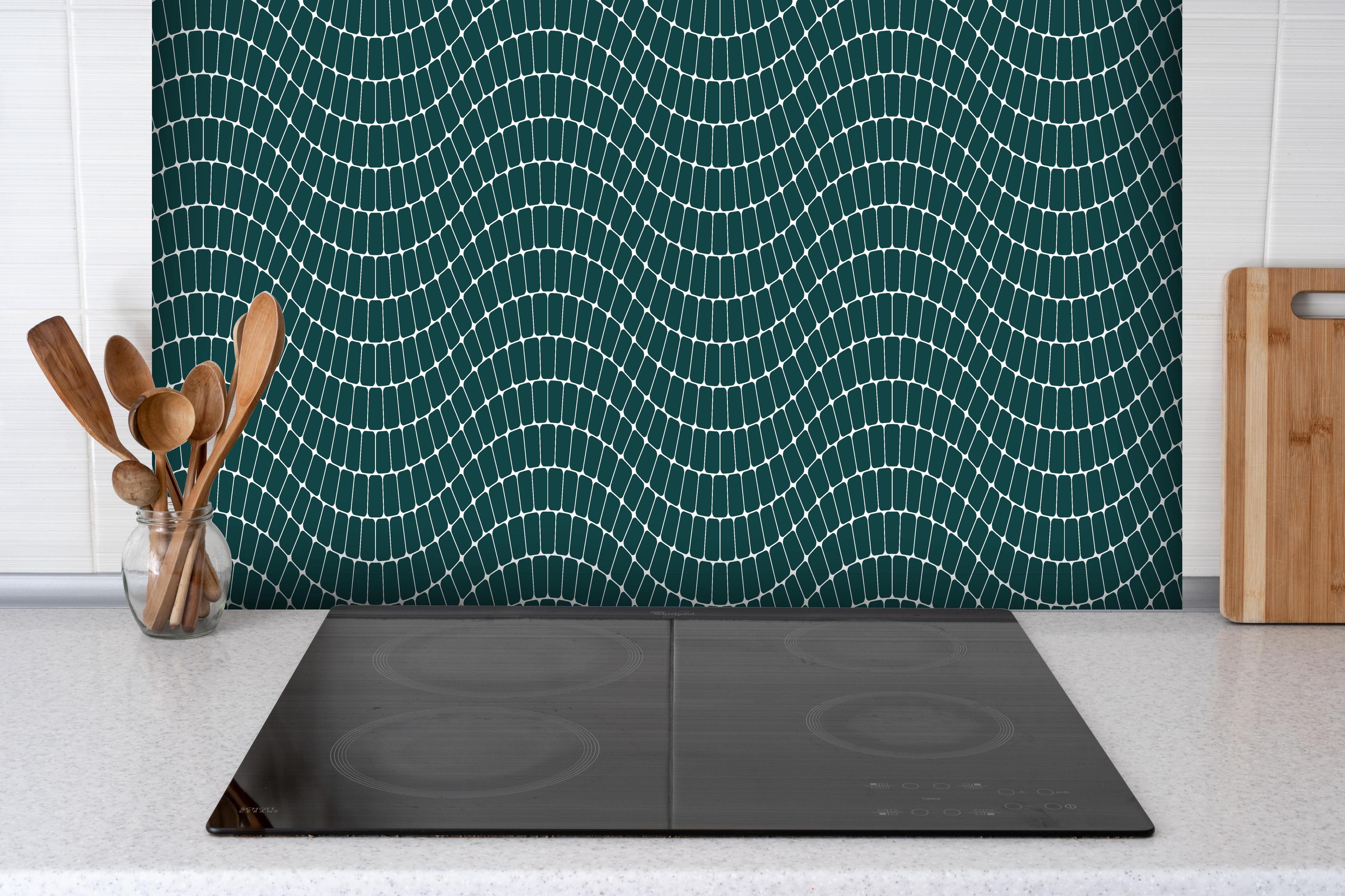 Spritzschutz - Onde Sinuoso Verde petrolio hinter einem Cerankochfeld zwischen Holz-Kochutensilien
