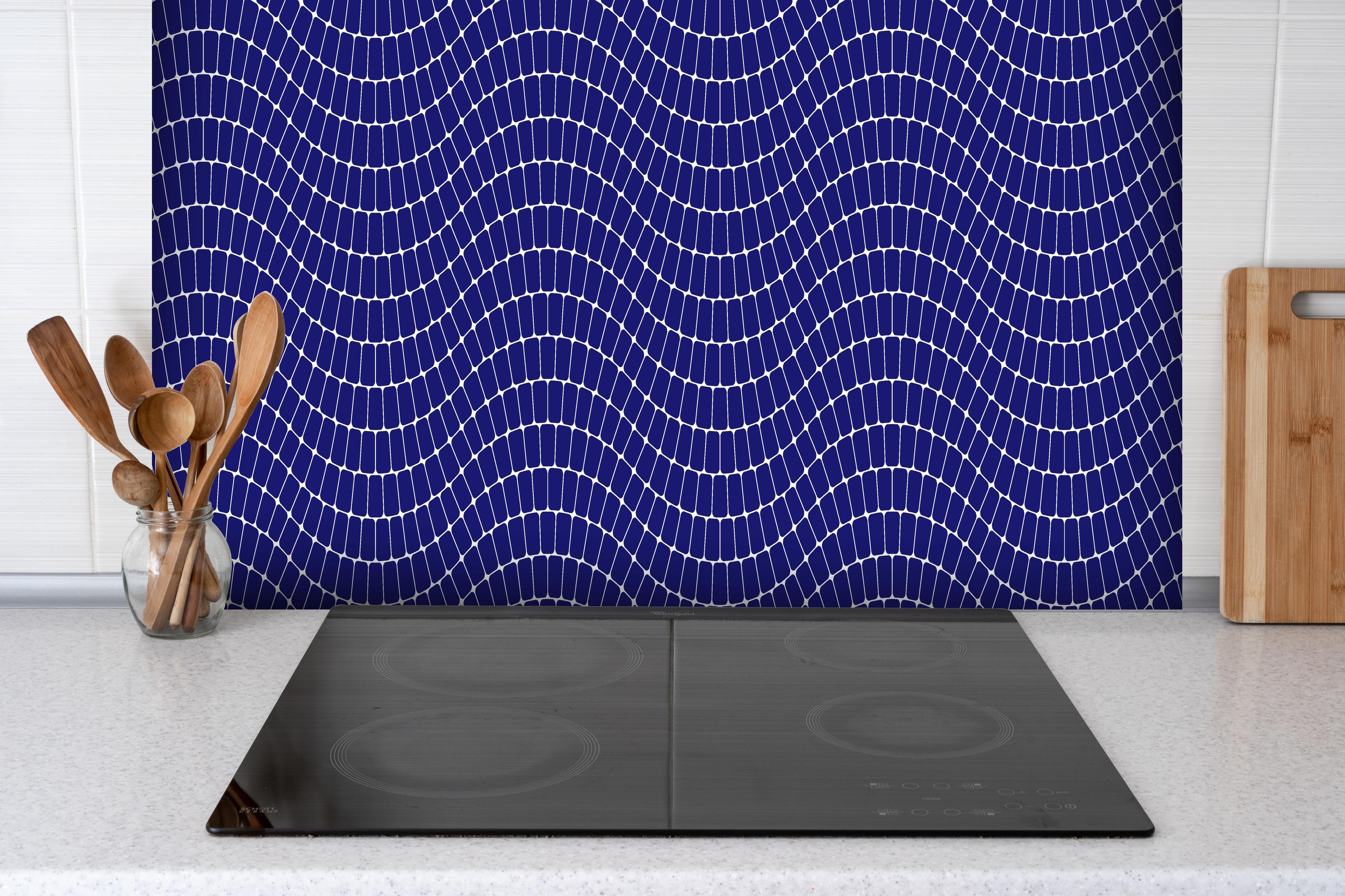 Spritzschutz - Onde Sinuoso Zaffiro hinter einem Cerankochfeld zwischen Holz-Kochutensilien