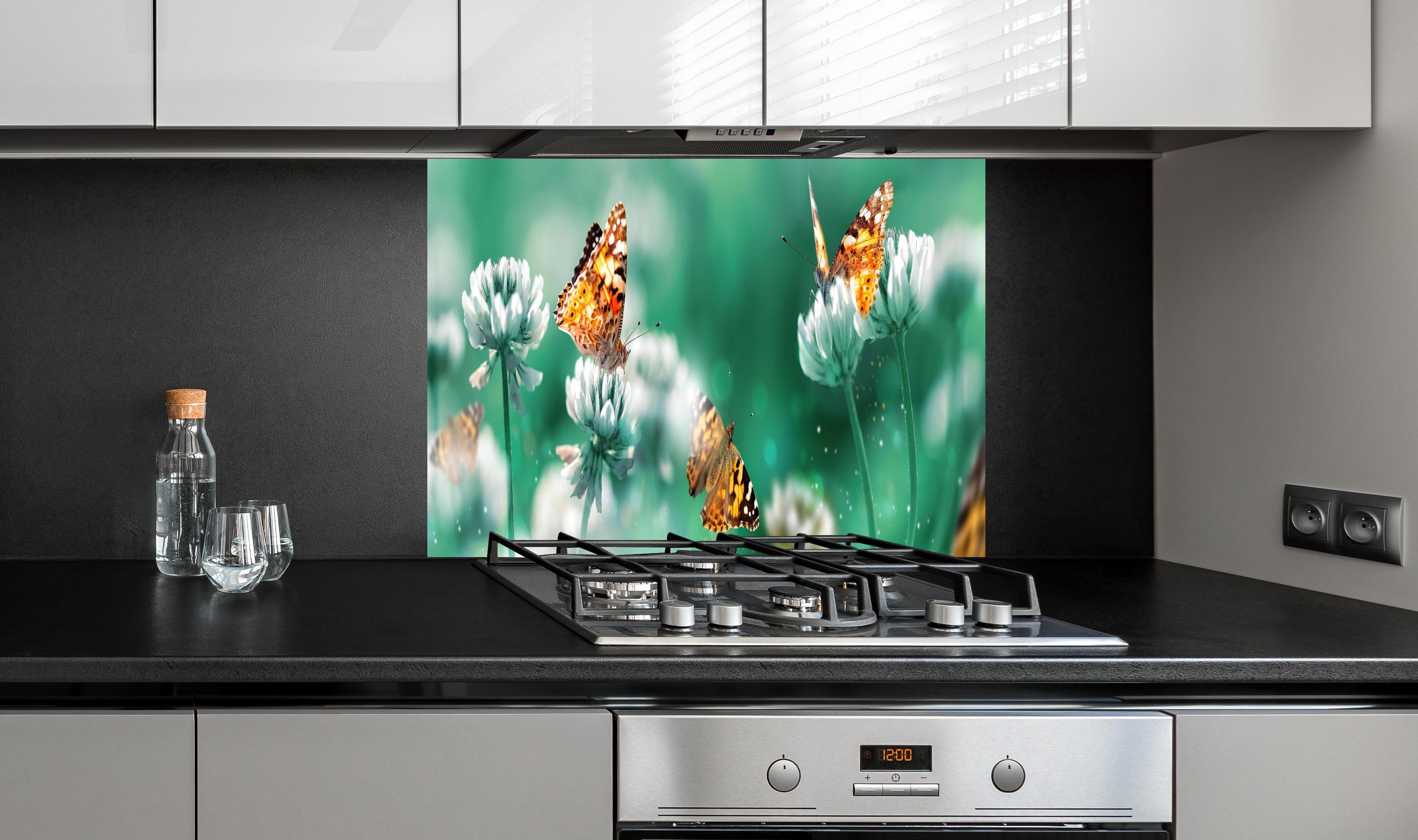 Spritzschutz - Orange Schmetterlinge Sommergarten hinter einem Cerankochfeld zwischen Holz-Kochutensilien