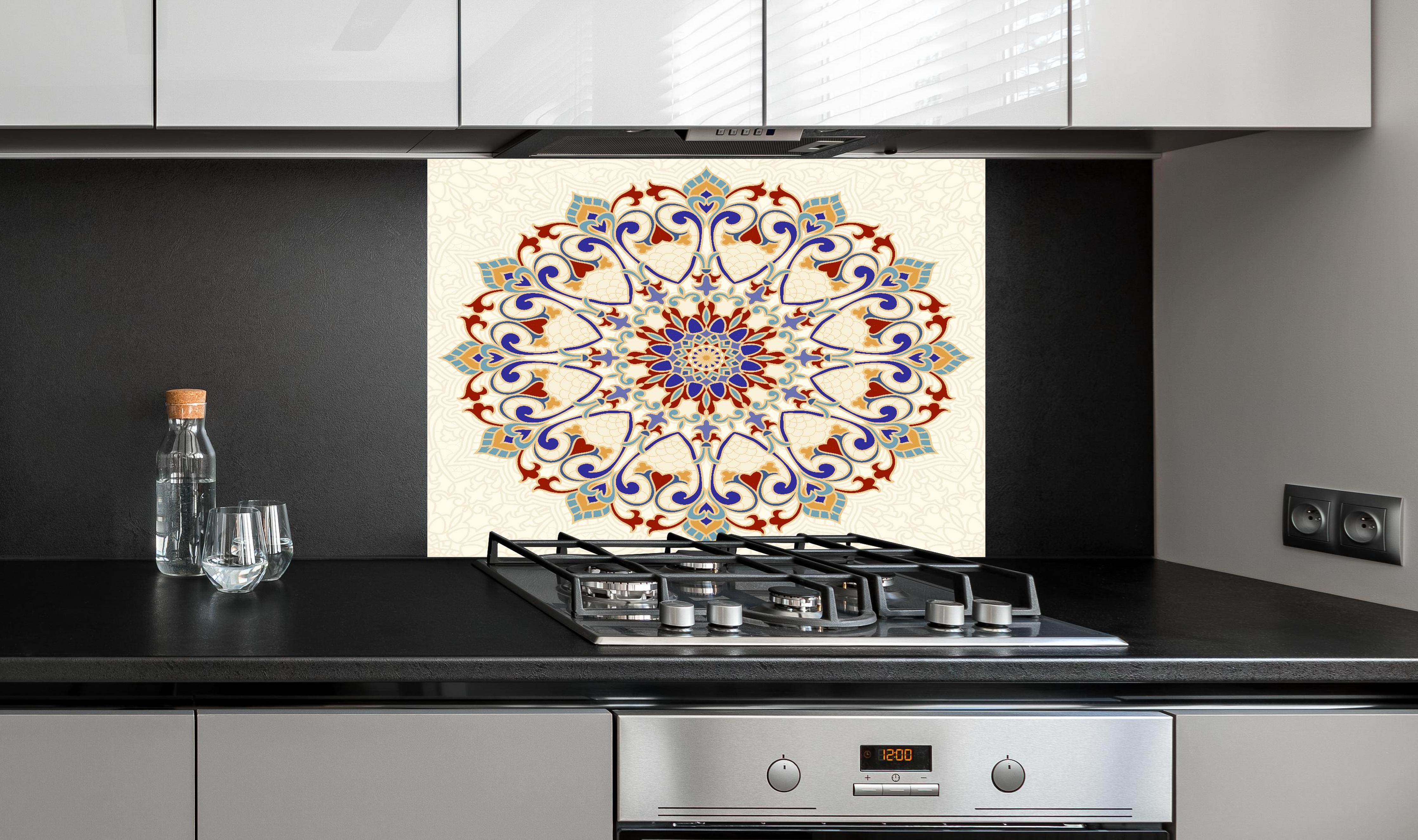 Spritzschutz - Ornamentales Mosaik Mandala in leuchtenden Farben hinter einem Cerankochfeld zwischen Holz-Kochutensilien