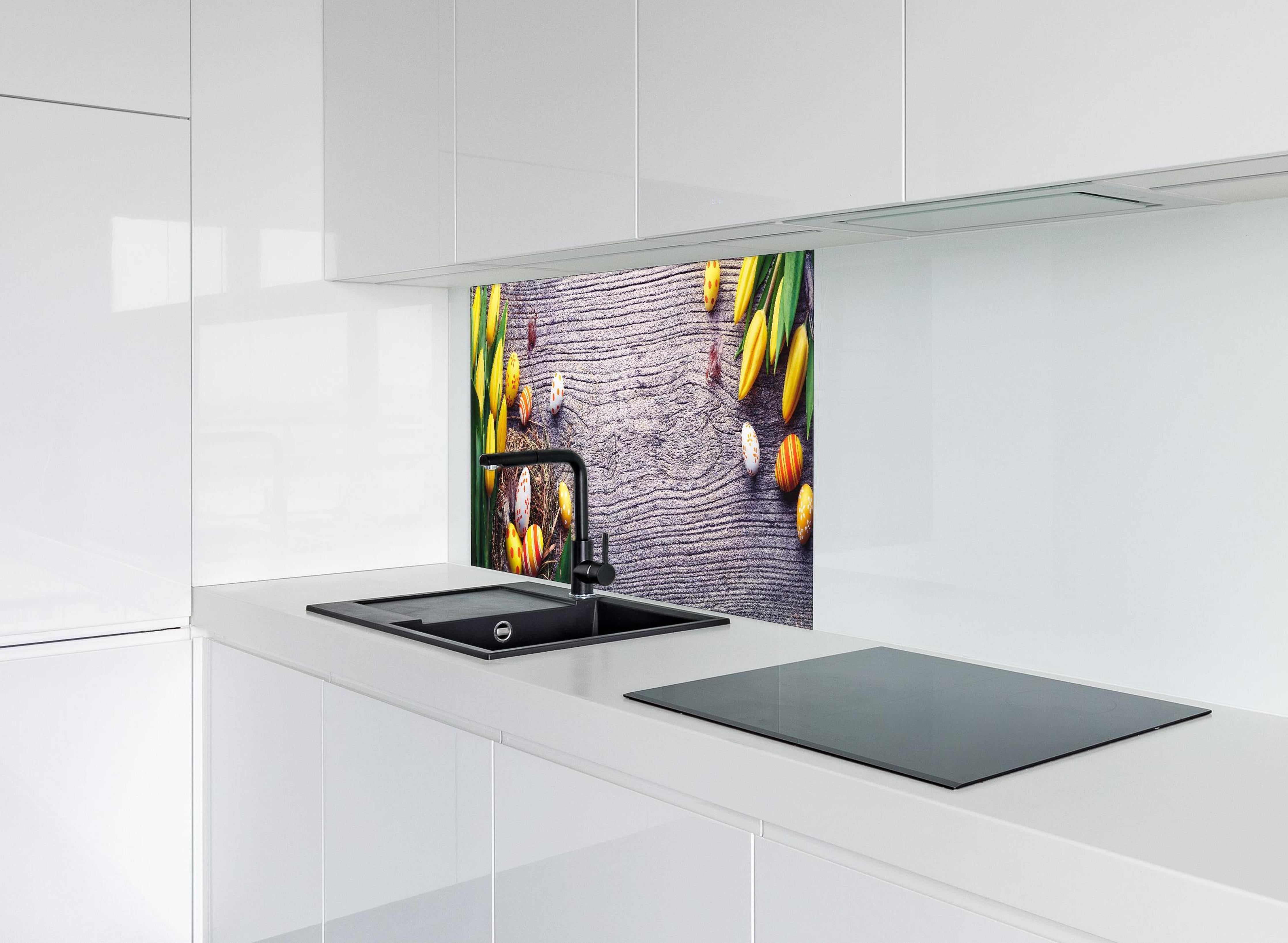 Spritzschutz - Ostereier auf Holztisch hinter einem Cerankochfeld zwischen Holz-Kochutensilien