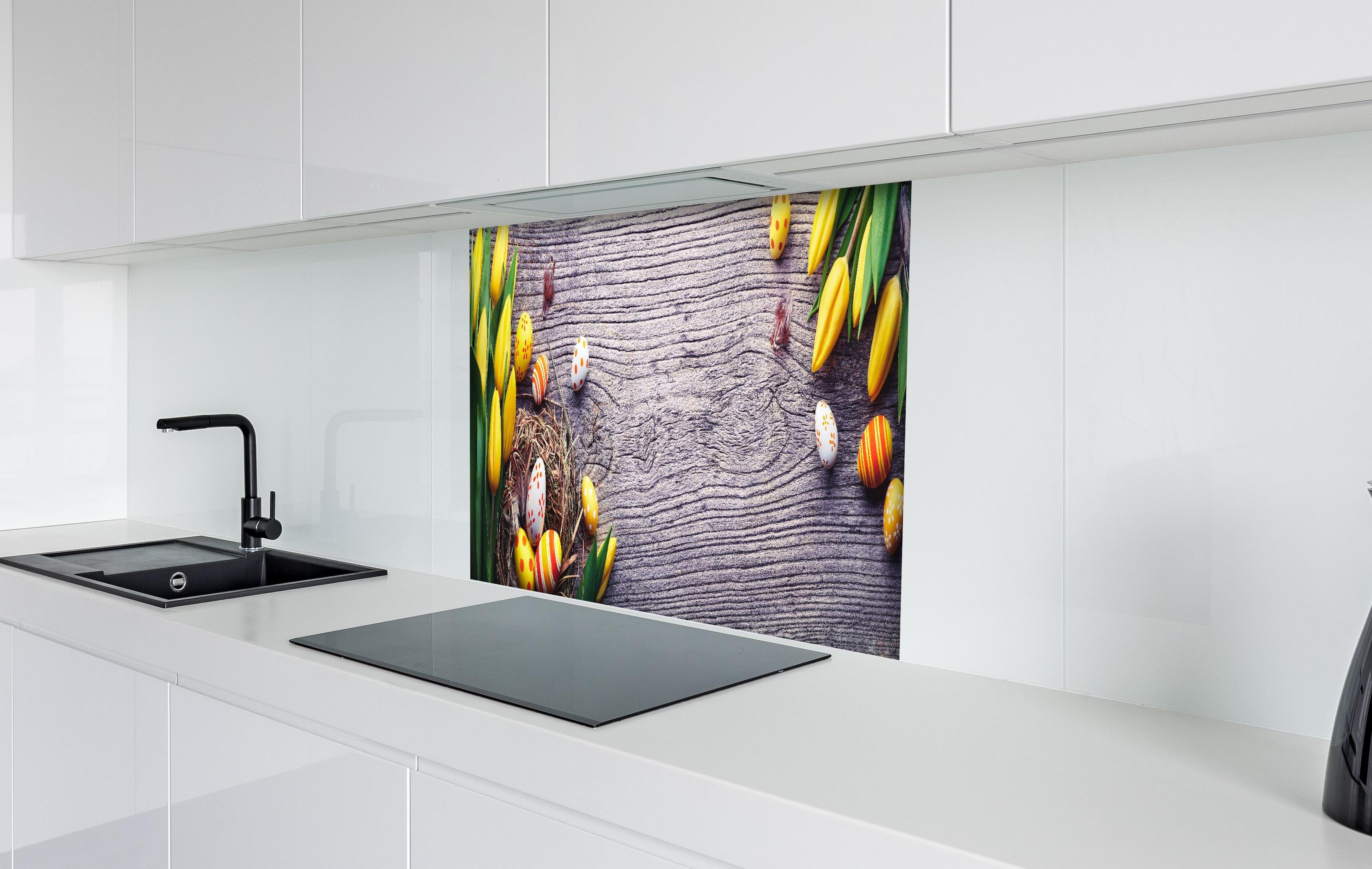 Spritzschutz - Ostereier auf Holztisch hinter einem Cerankochfeld zwischen Holz-Kochutensilien