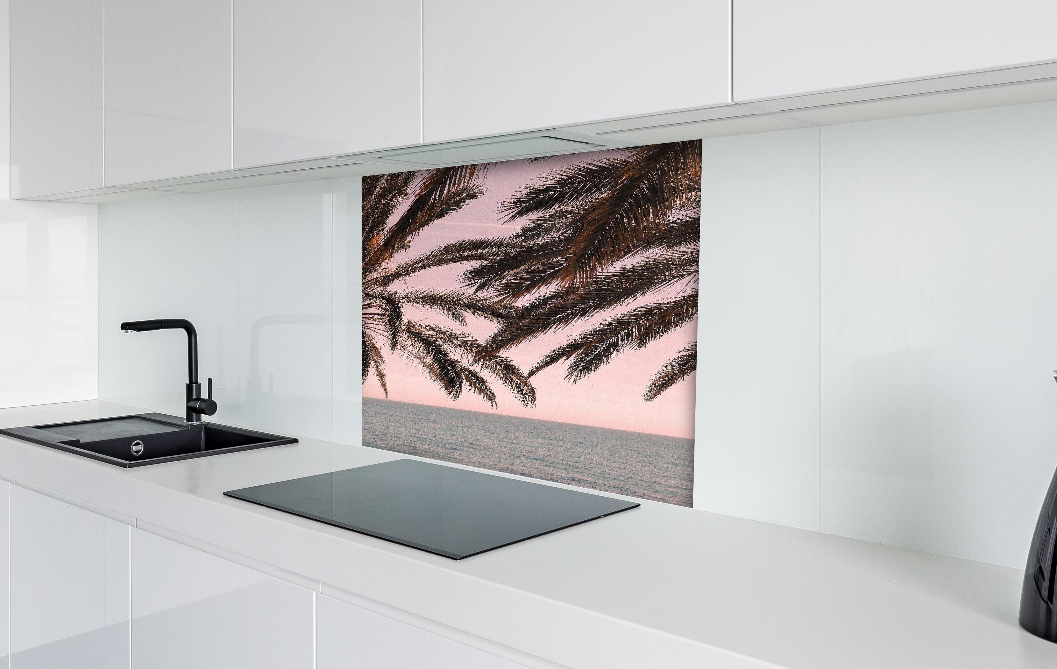 Spritzschutz - Palmen an der Küste hinter einem Cerankochfeld zwischen Holz-Kochutensilien