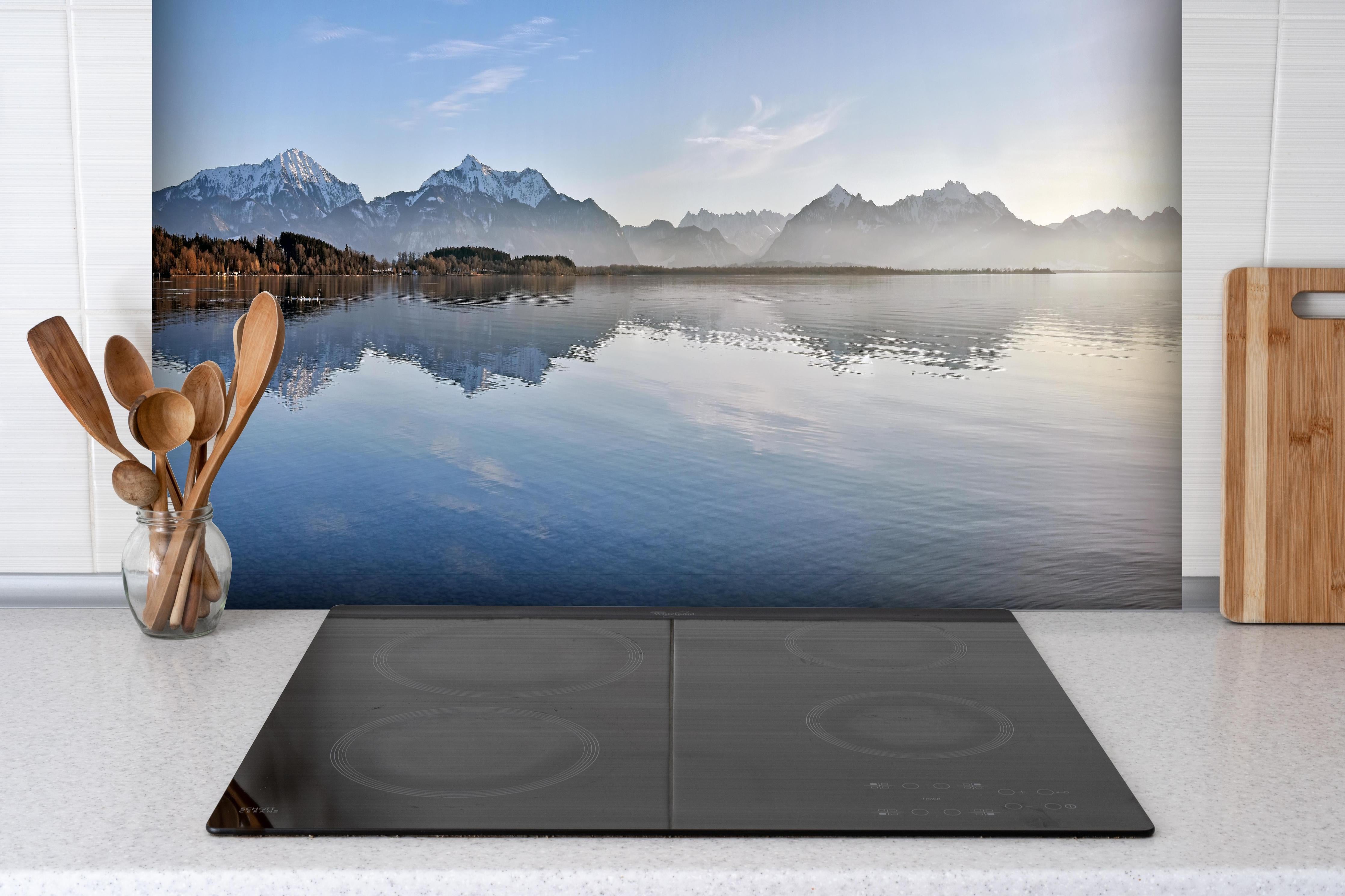 Spritzschutz - Panorama Bergsee bei Morgendämmerung Bild hinter einem Cerankochfeld zwischen Holz-Kochutensilien