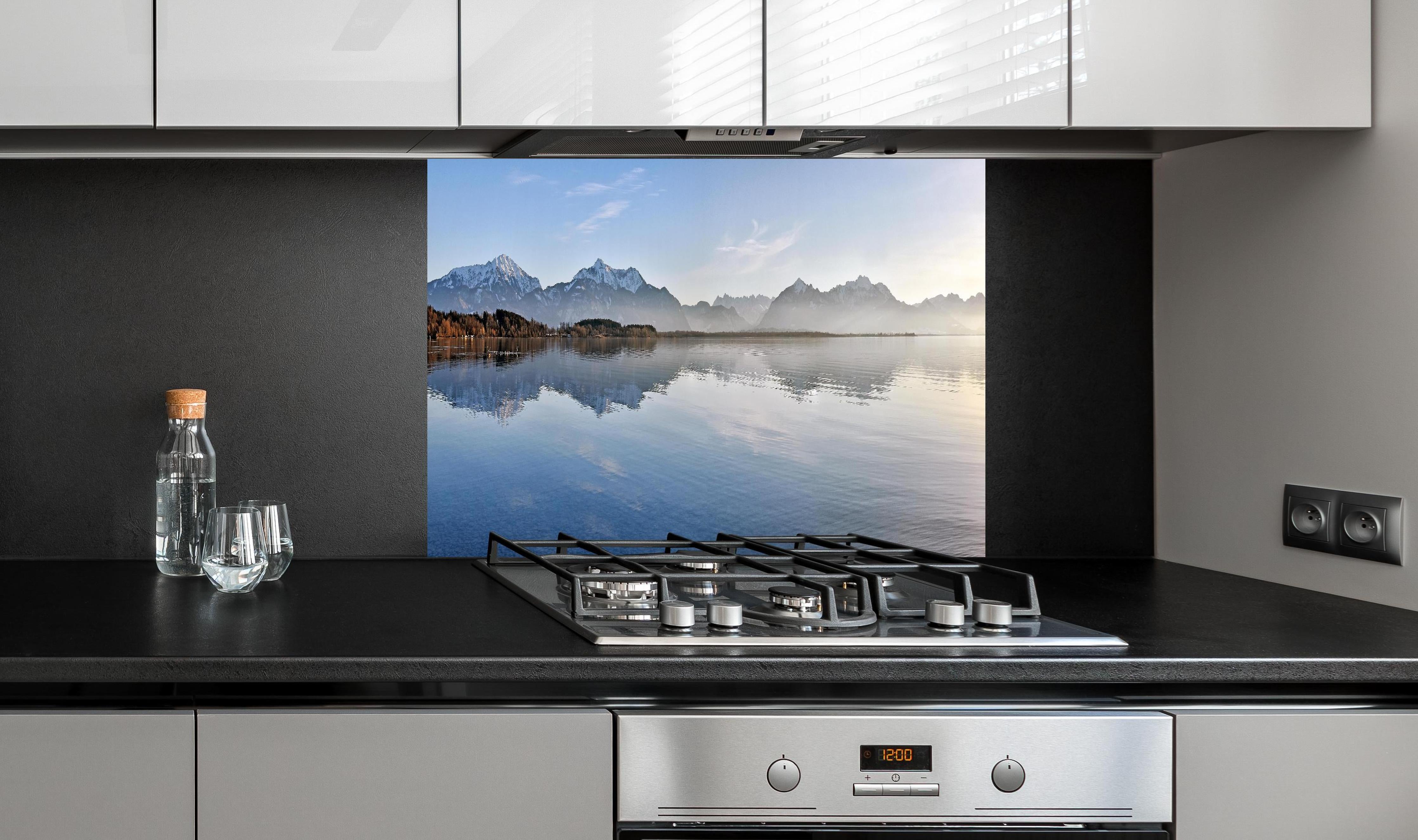 Spritzschutz - Panorama Bergsee bei Morgendämmerung Bild hinter einem Cerankochfeld zwischen Holz-Kochutensilien