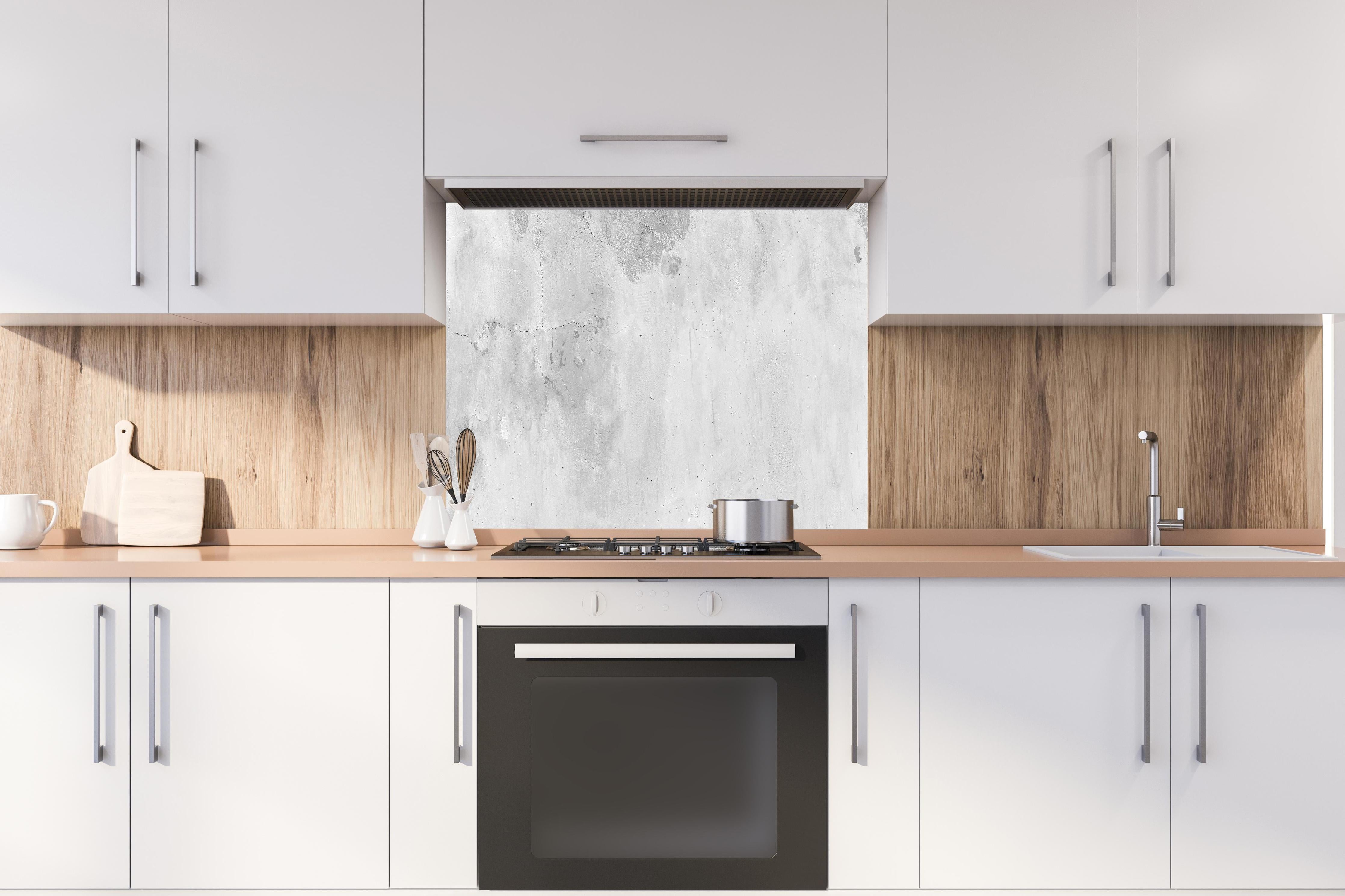 Spritzschutz - Panorama einer alten Betonwand hinter einem Cerankochfeld zwischen Holz-Kochutensilien