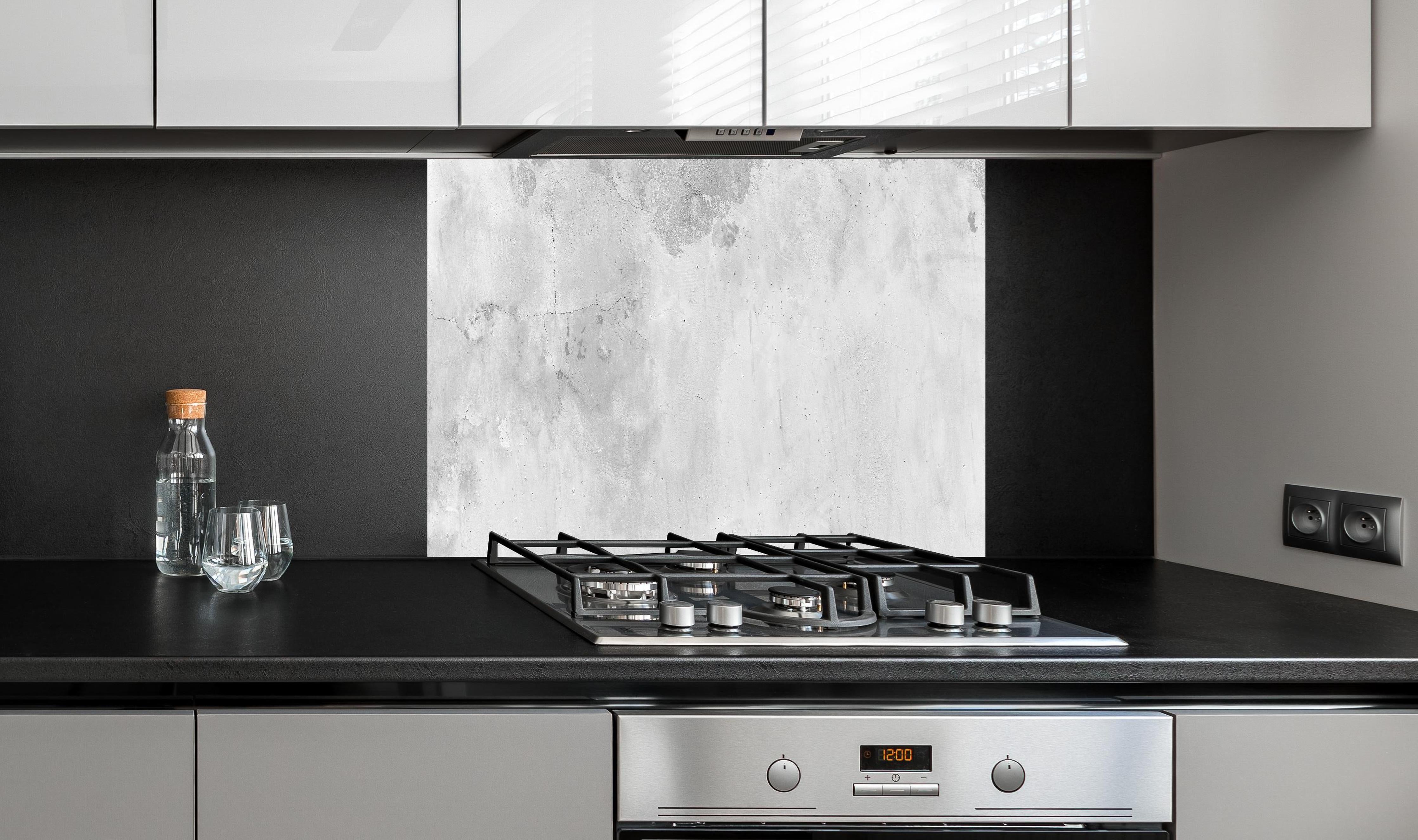 Spritzschutz - Panorama einer alten Betonwand hinter einem Cerankochfeld zwischen Holz-Kochutensilien