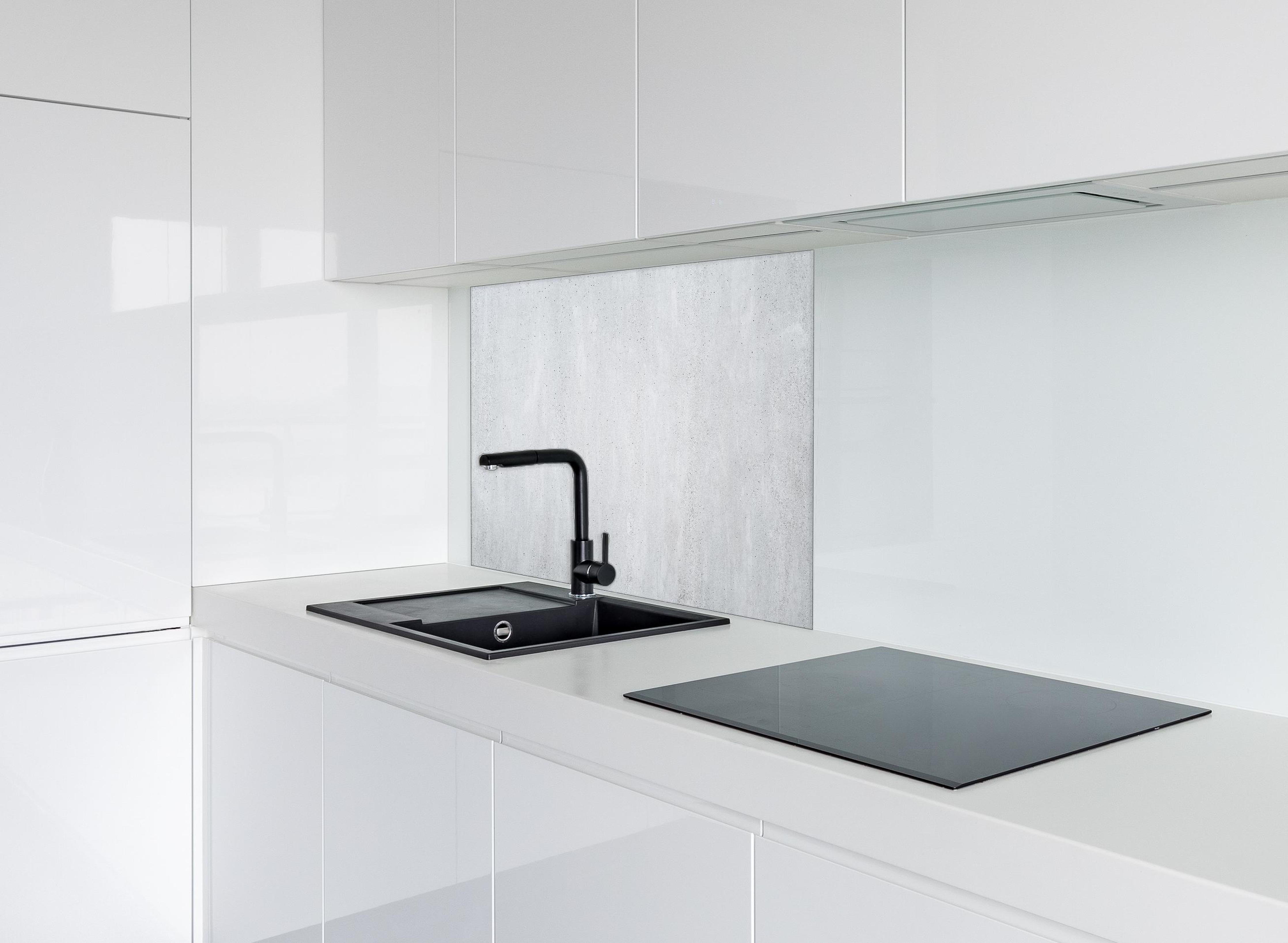 Spritzschutz - Panorama einer glatten grauen Betonwand hinter einem Cerankochfeld zwischen Holz-Kochutensilien