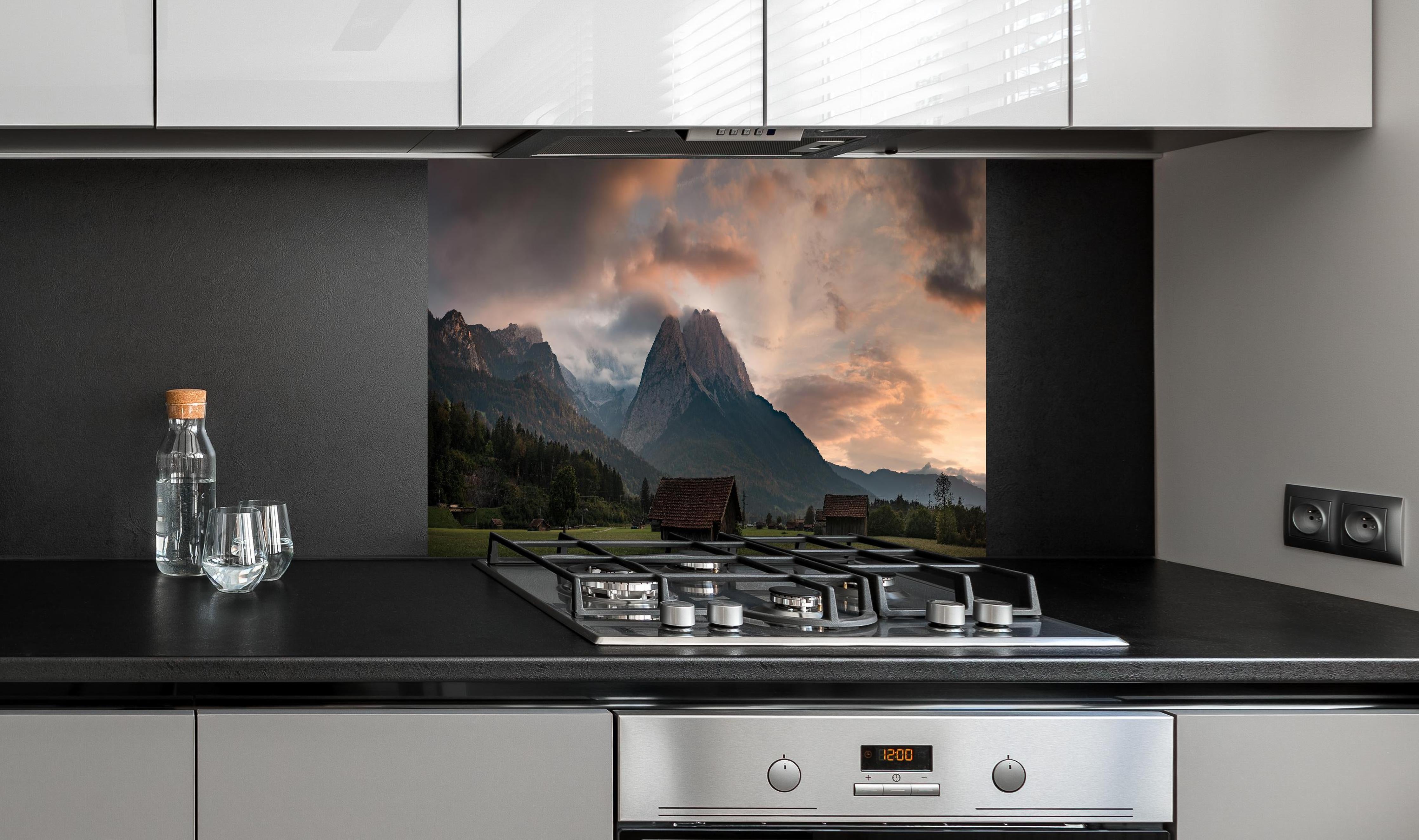 Spritzschutz - Panorama von der wolkenverhangenen Zugspitze hinter einem Cerankochfeld zwischen Holz-Kochutensilien