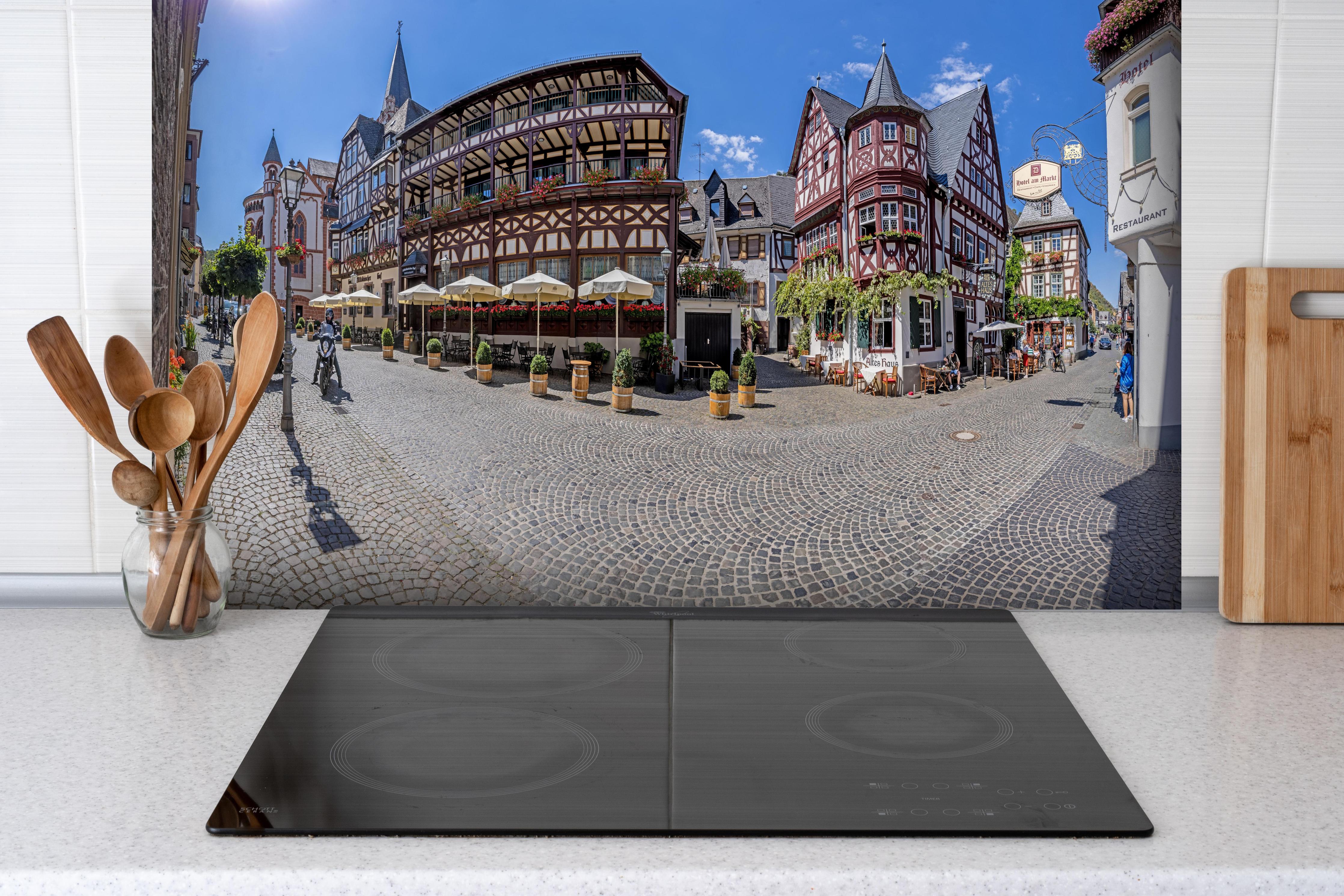 Spritzschutz - Panoramablick über Bacharach hinter einem Cerankochfeld zwischen Holz-Kochutensilien