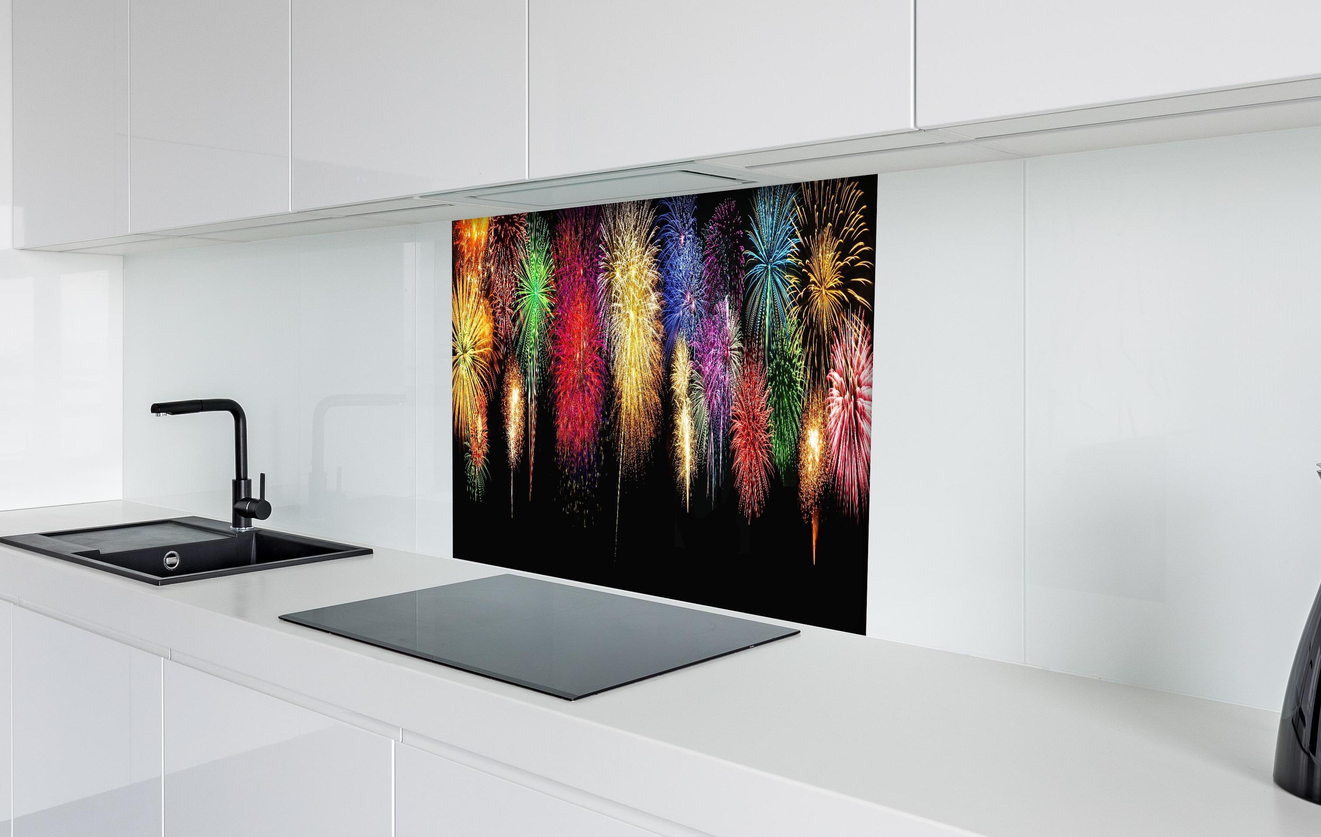 Spritzschutz - Panoramisches Silvesterfeuerwerk in leuchtenden Farben hinter einem Cerankochfeld zwischen Holz-Kochutensilien