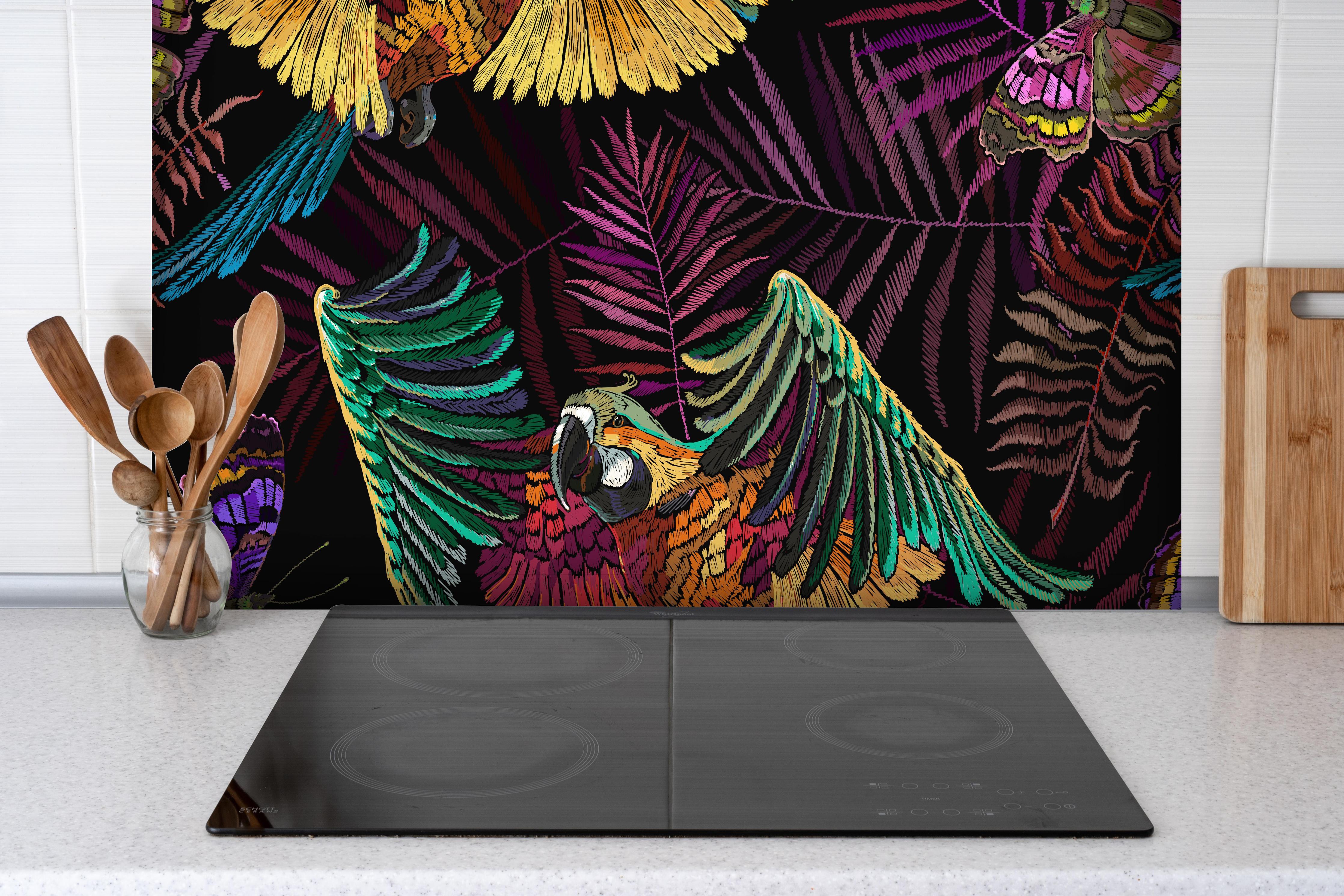 Spritzschutz - Papagaien - Stickmuster hinter einem Cerankochfeld zwischen Holz-Kochutensilien