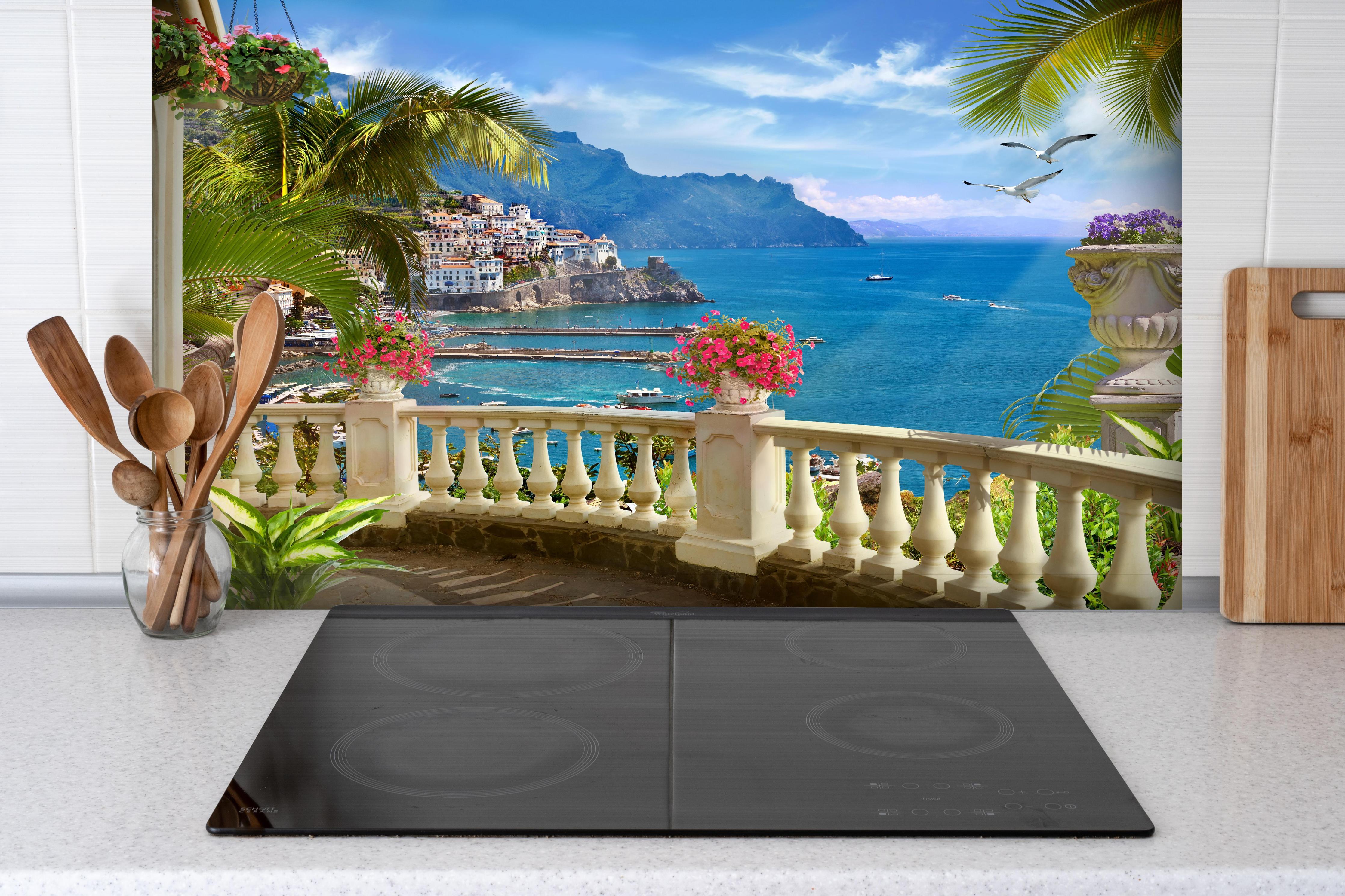 Spritzschutz - Paradiesischer Ausblick vom Balkon in Sizilien hinter einem Cerankochfeld zwischen Holz-Kochutensilien