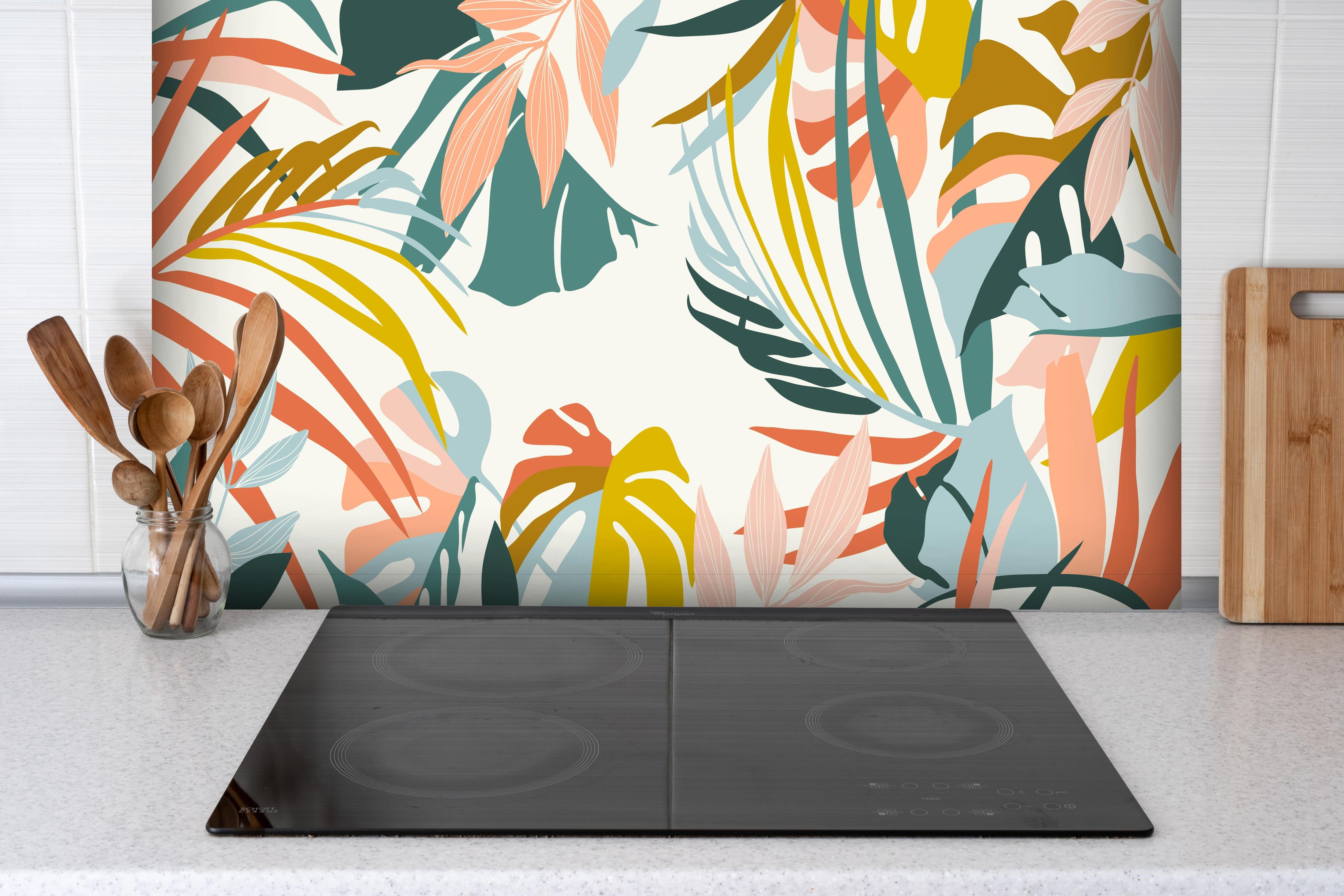 Spritzschutz - Pastell Tropenblätter stilvolle Wanddekoration hinter einem Cerankochfeld zwischen Holz-Kochutensilien