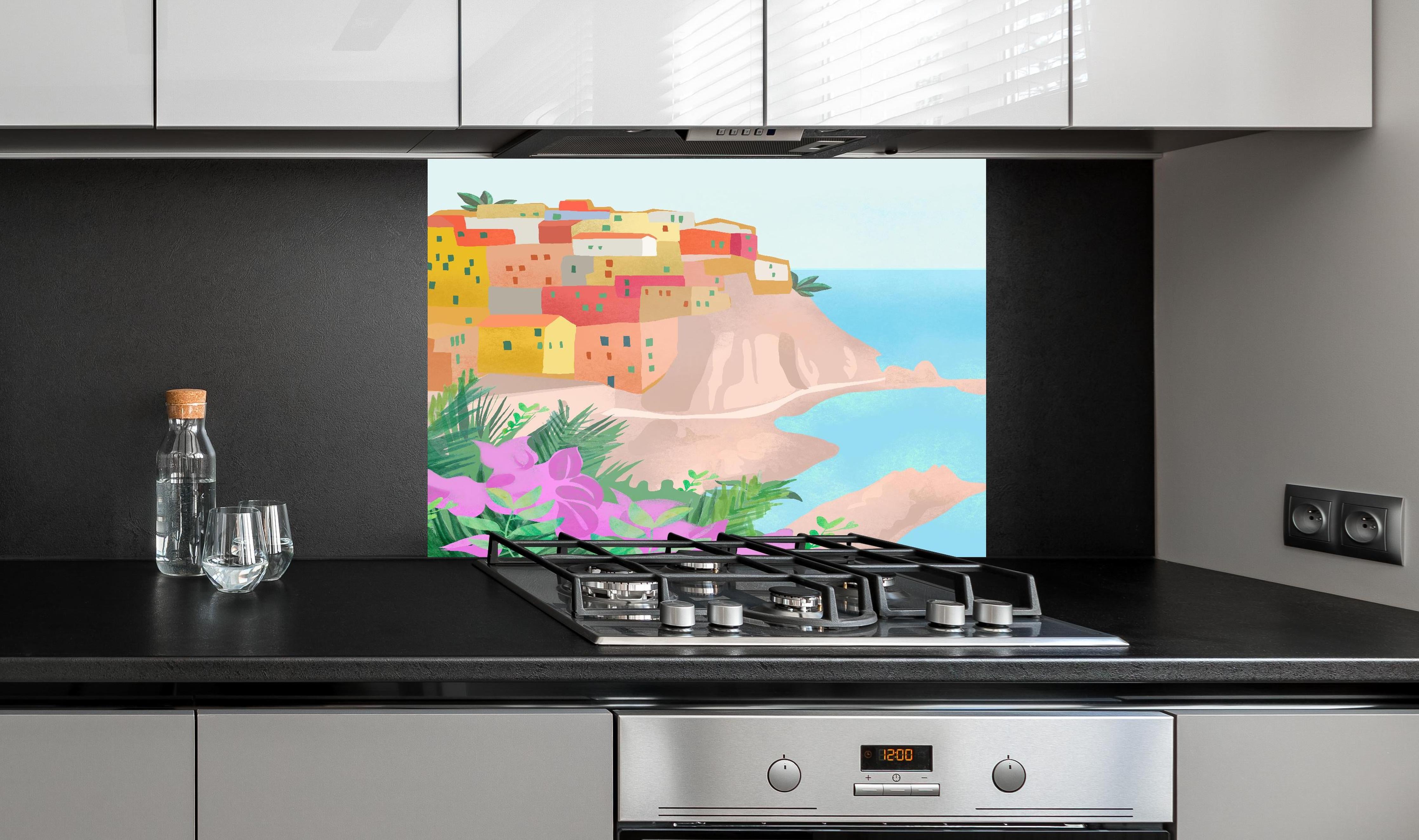 Spritzschutz - Pastellfarbene Cinque Terre Dorfansicht hinter einem Cerankochfeld zwischen Holz-Kochutensilien