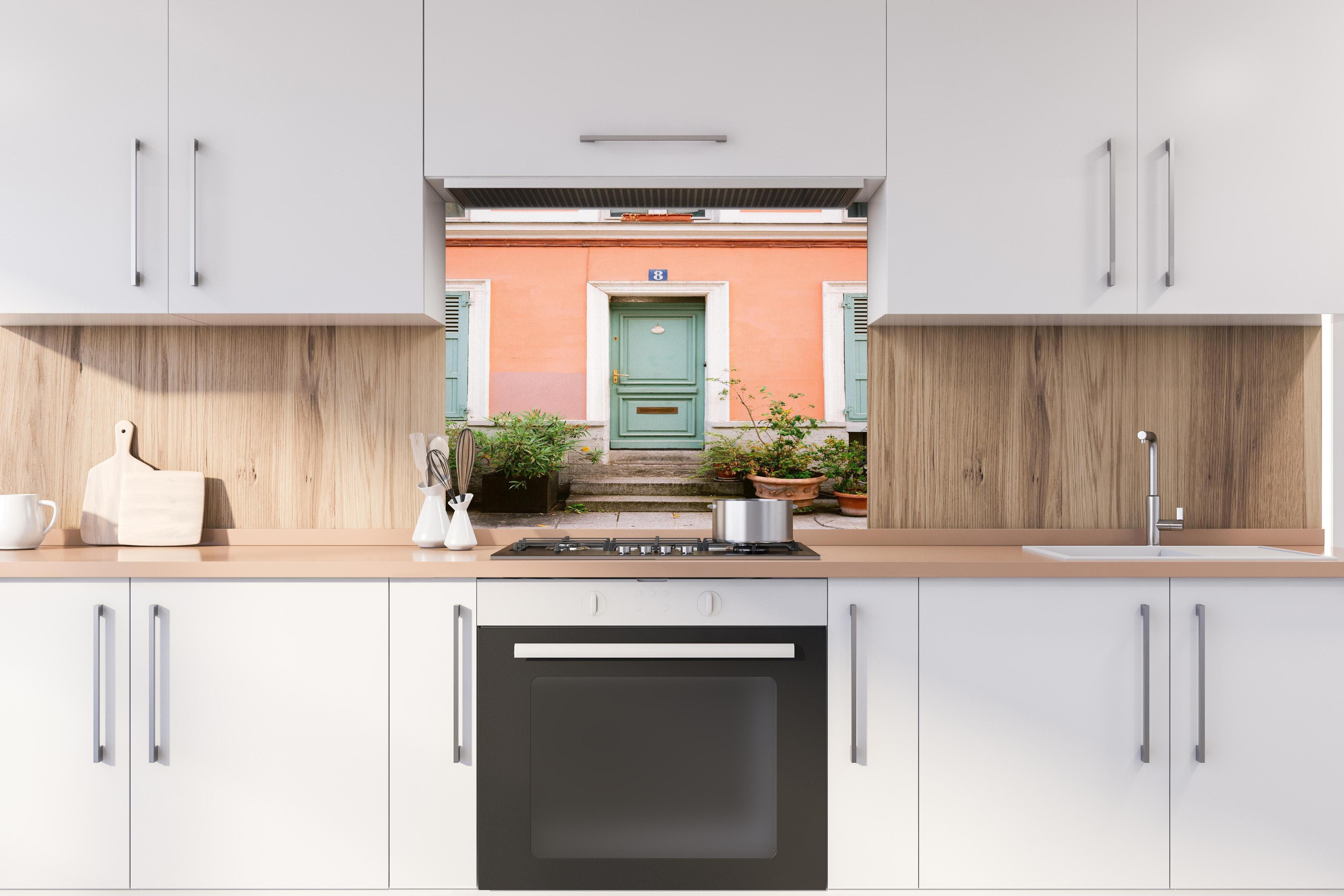 Spritzschutz - Pastellfarbene Tür Rue Cremieux Paris hinter einem Cerankochfeld zwischen Holz-Kochutensilien