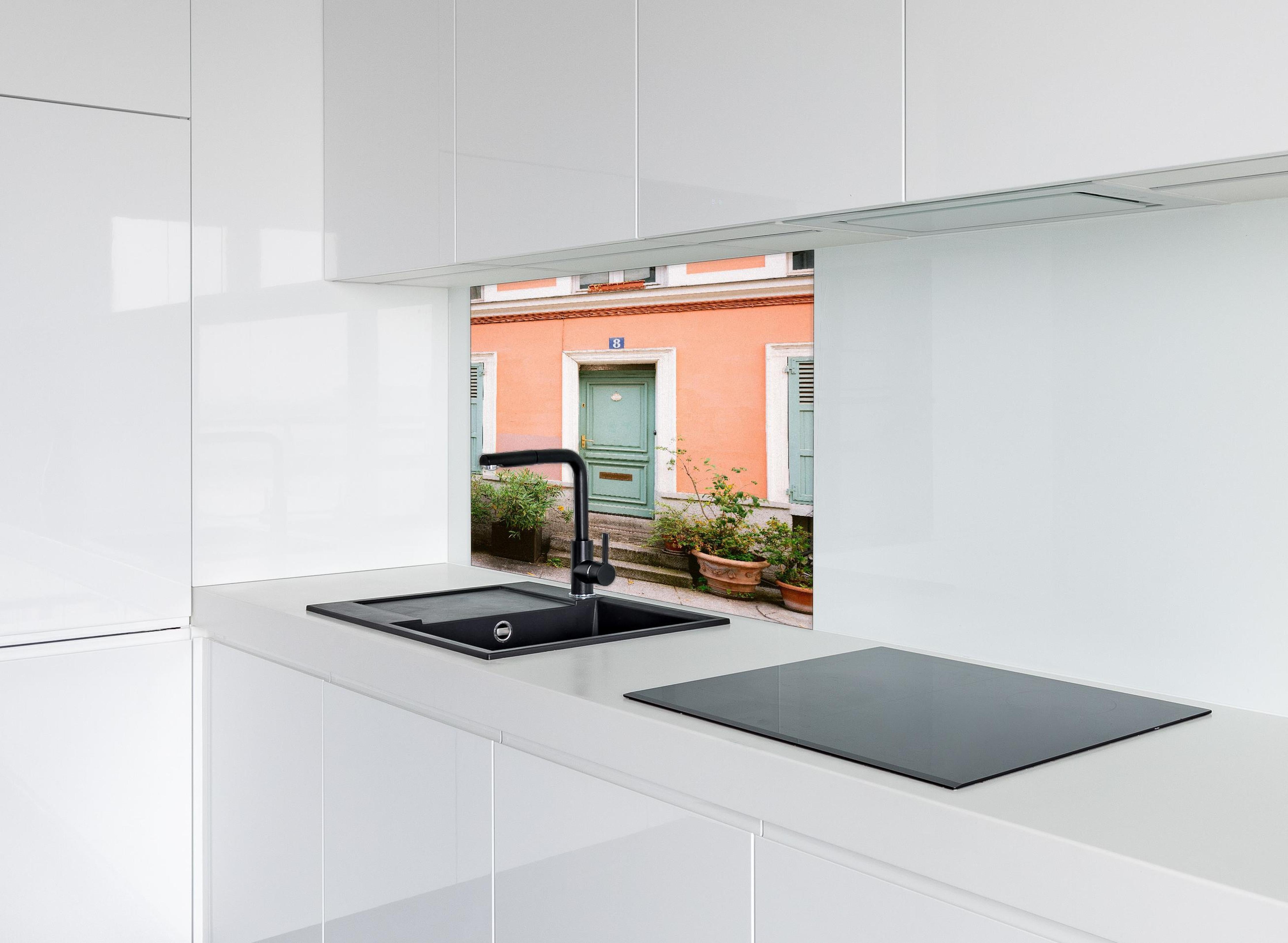 Spritzschutz - Pastellfarbene Tür Rue Cremieux Paris hinter einem Cerankochfeld zwischen Holz-Kochutensilien