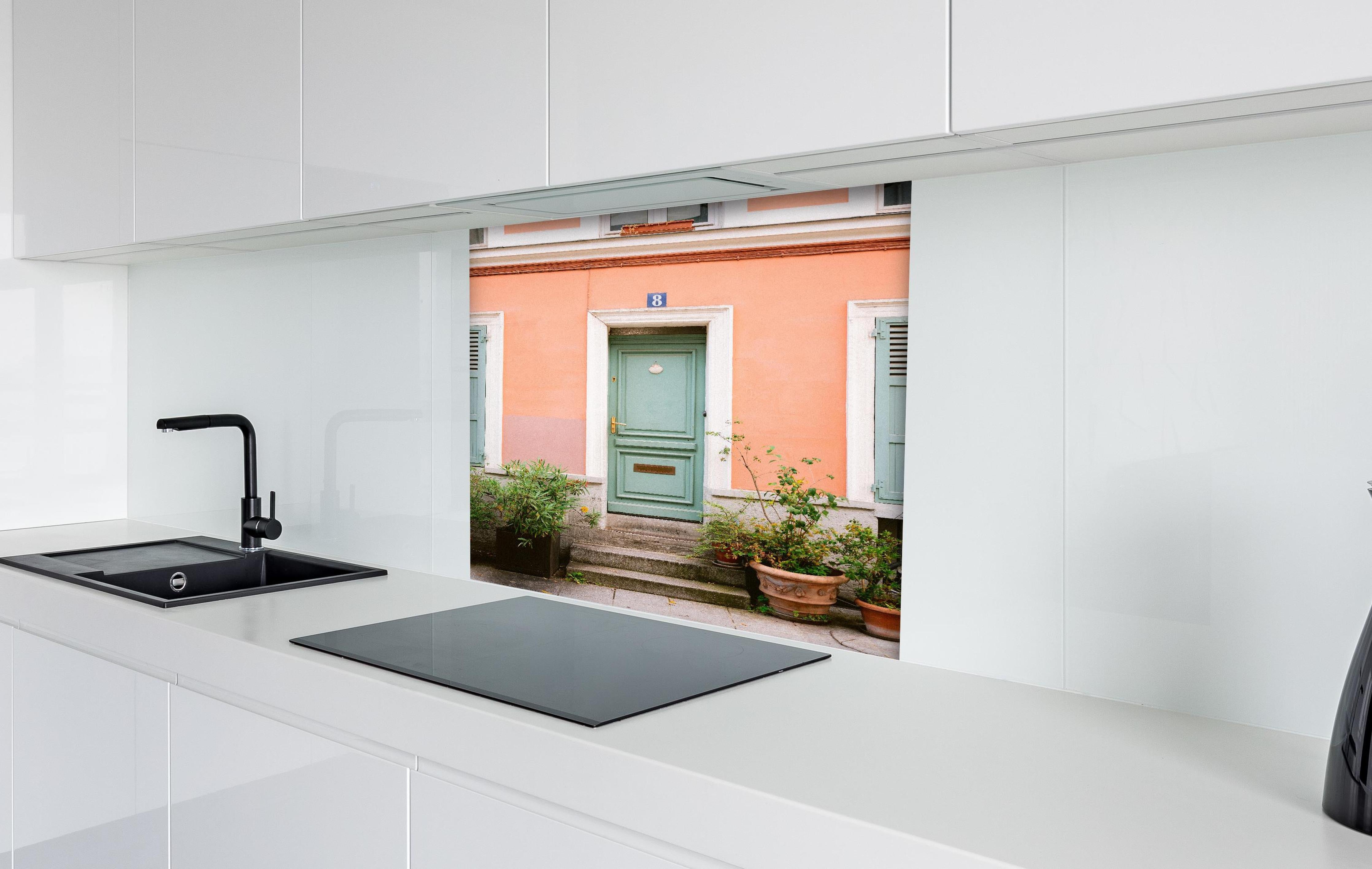 Spritzschutz - Pastellfarbene Tür Rue Cremieux Paris hinter einem Cerankochfeld zwischen Holz-Kochutensilien