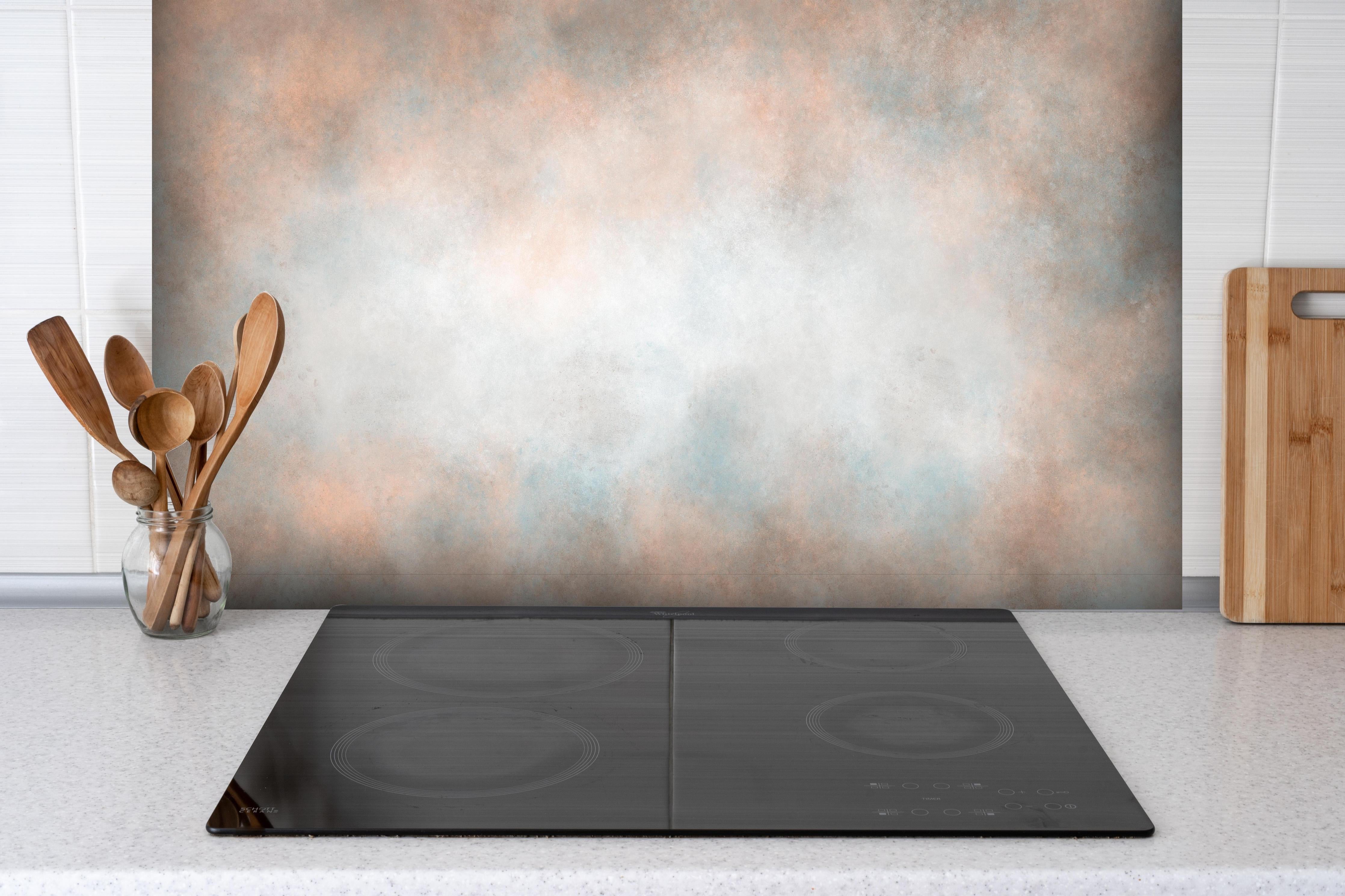 Spritzschutz - Pastellfarbiges beige-blaues Design hinter einem Cerankochfeld zwischen Holz-Kochutensilien