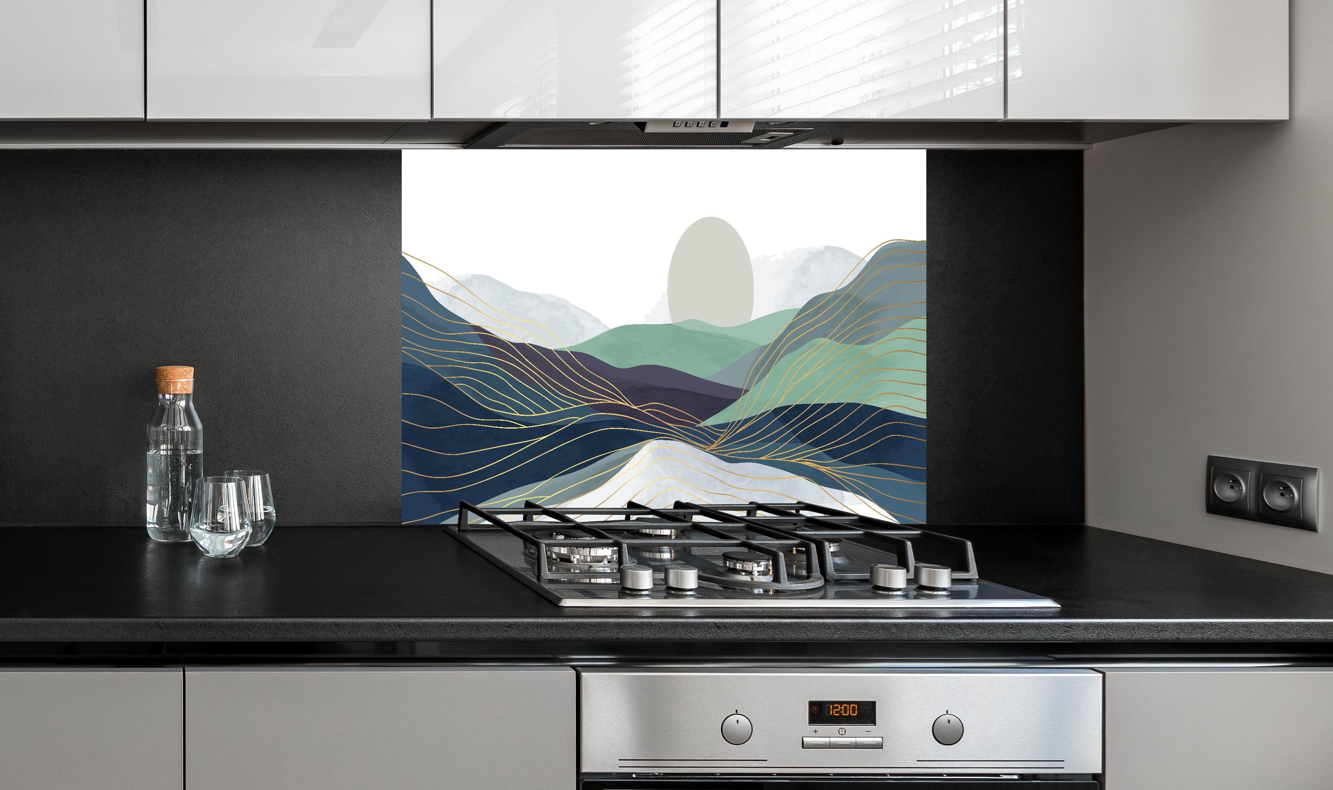 Spritzschutz - Pastellige Hügel Grafik mit Sonnenmotiv hinter einem Cerankochfeld zwischen Holz-Kochutensilien