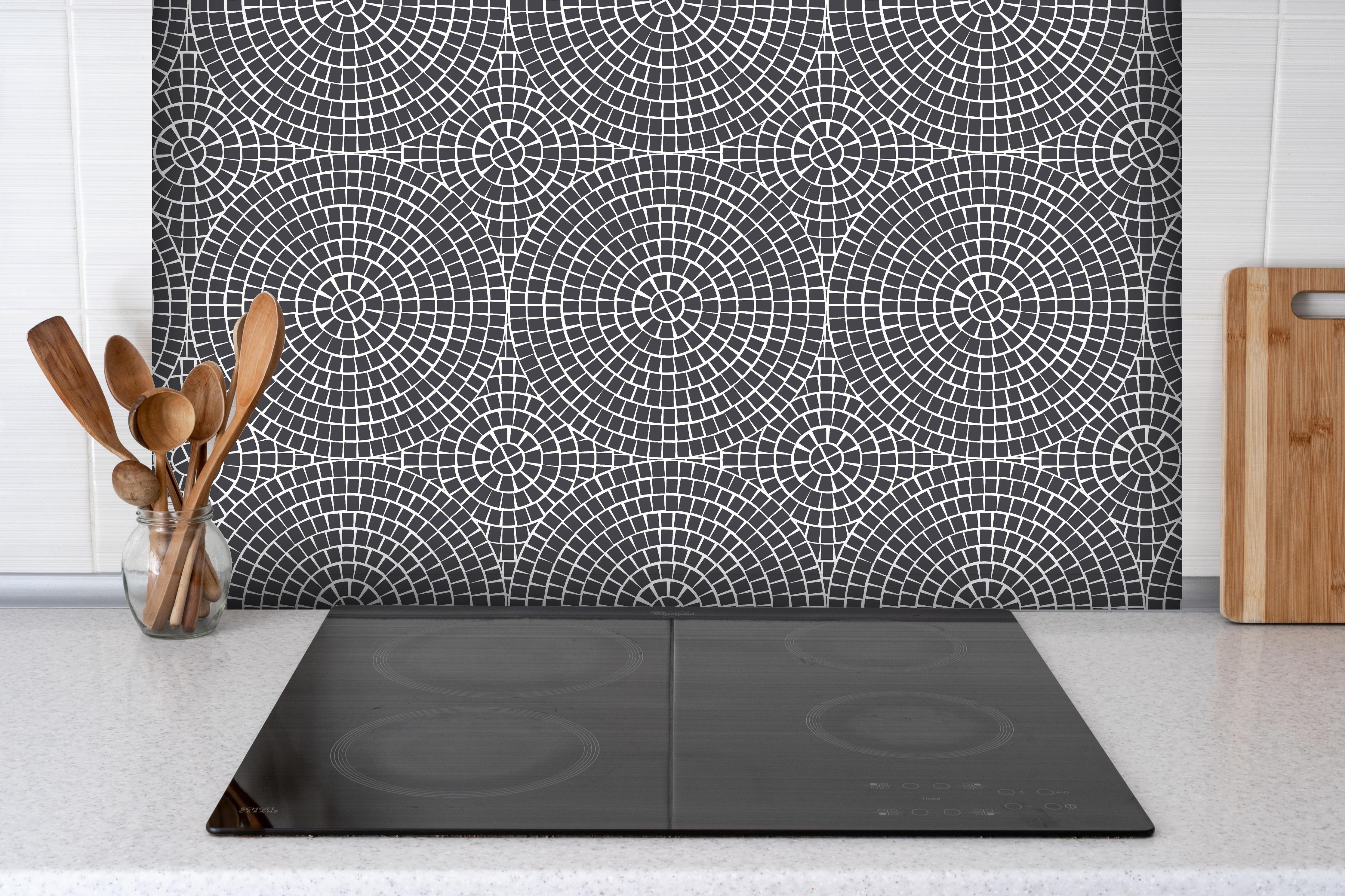 Spritzschutz - Pietre Mosaico Antracite hinter einem Cerankochfeld zwischen Holz-Kochutensilien