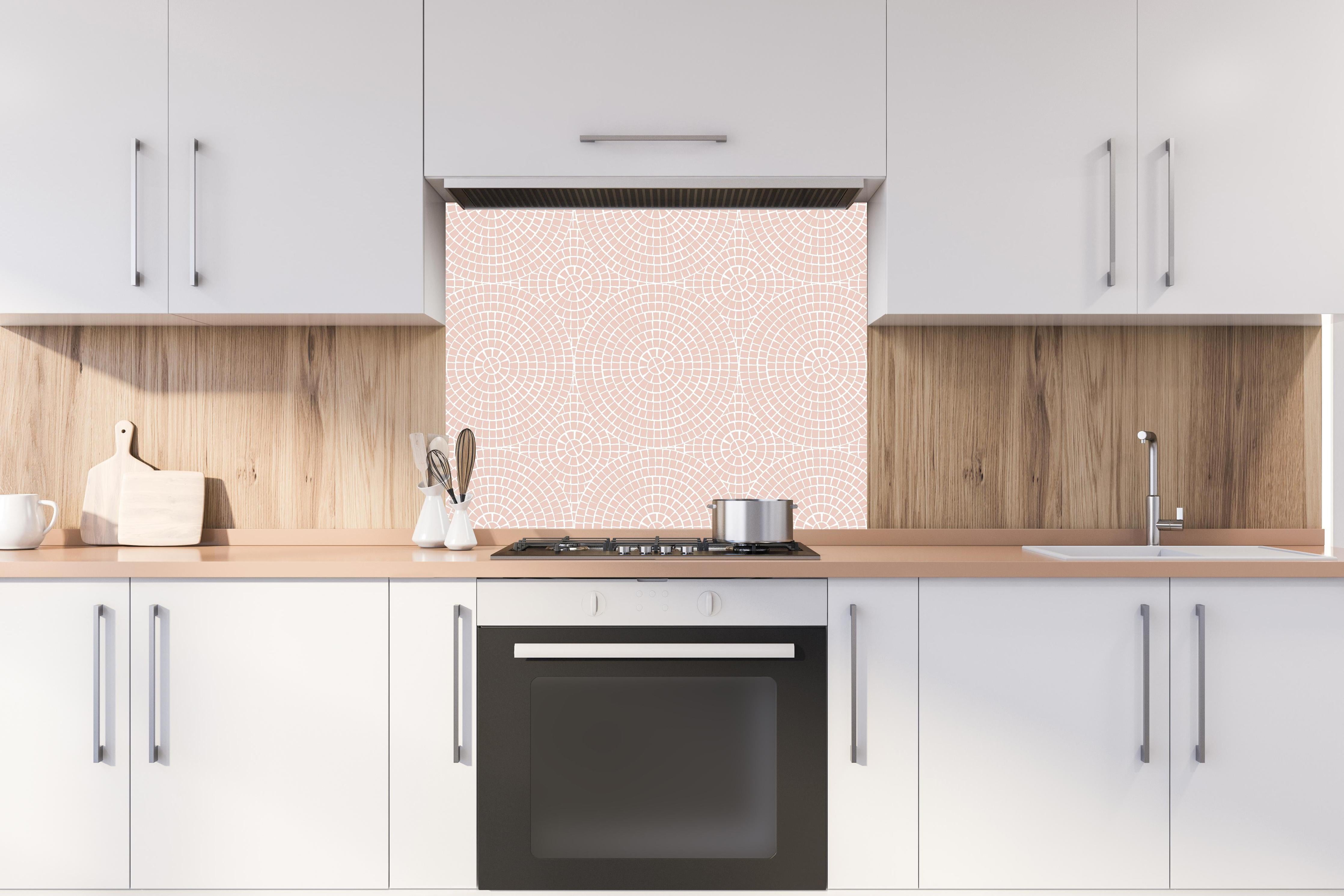 Spritzschutz - Pietre Mosaico Cipria hinter einem Cerankochfeld zwischen Holz-Kochutensilien