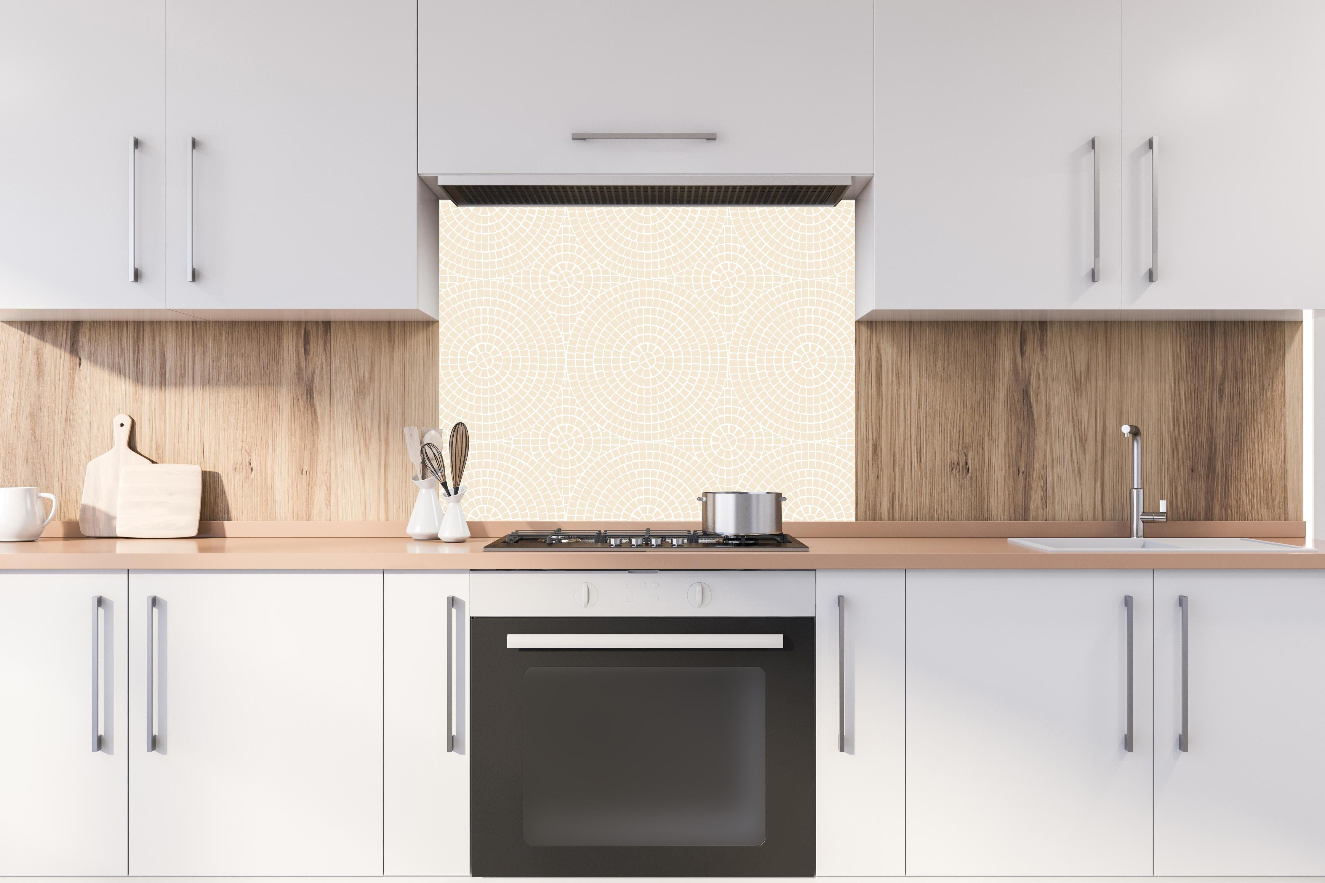 Spritzschutz - Pietre Mosaico Crema hinter einem Cerankochfeld zwischen Holz-Kochutensilien