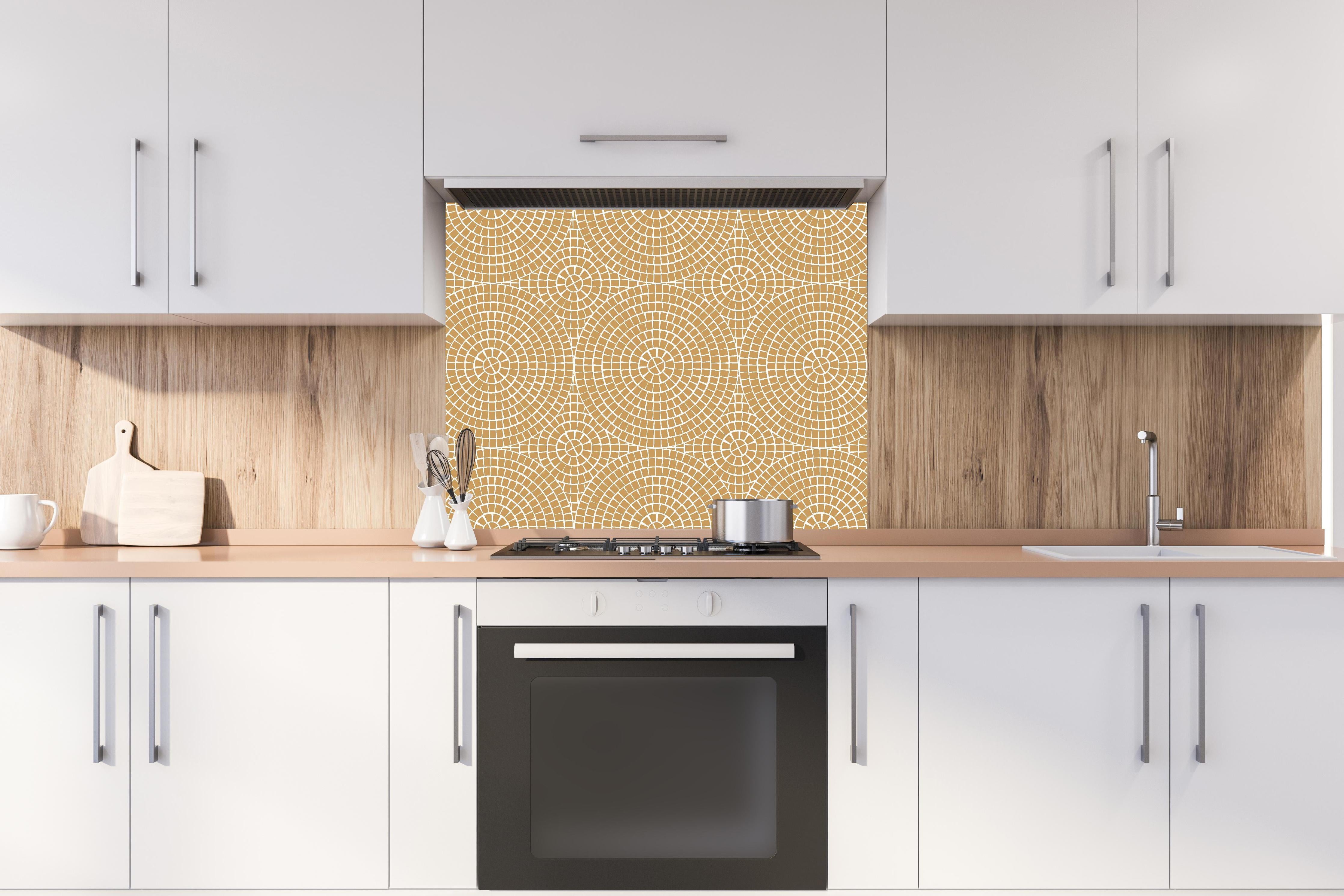 Spritzschutz - Pietre Mosaico Ocra hinter einem Cerankochfeld zwischen Holz-Kochutensilien