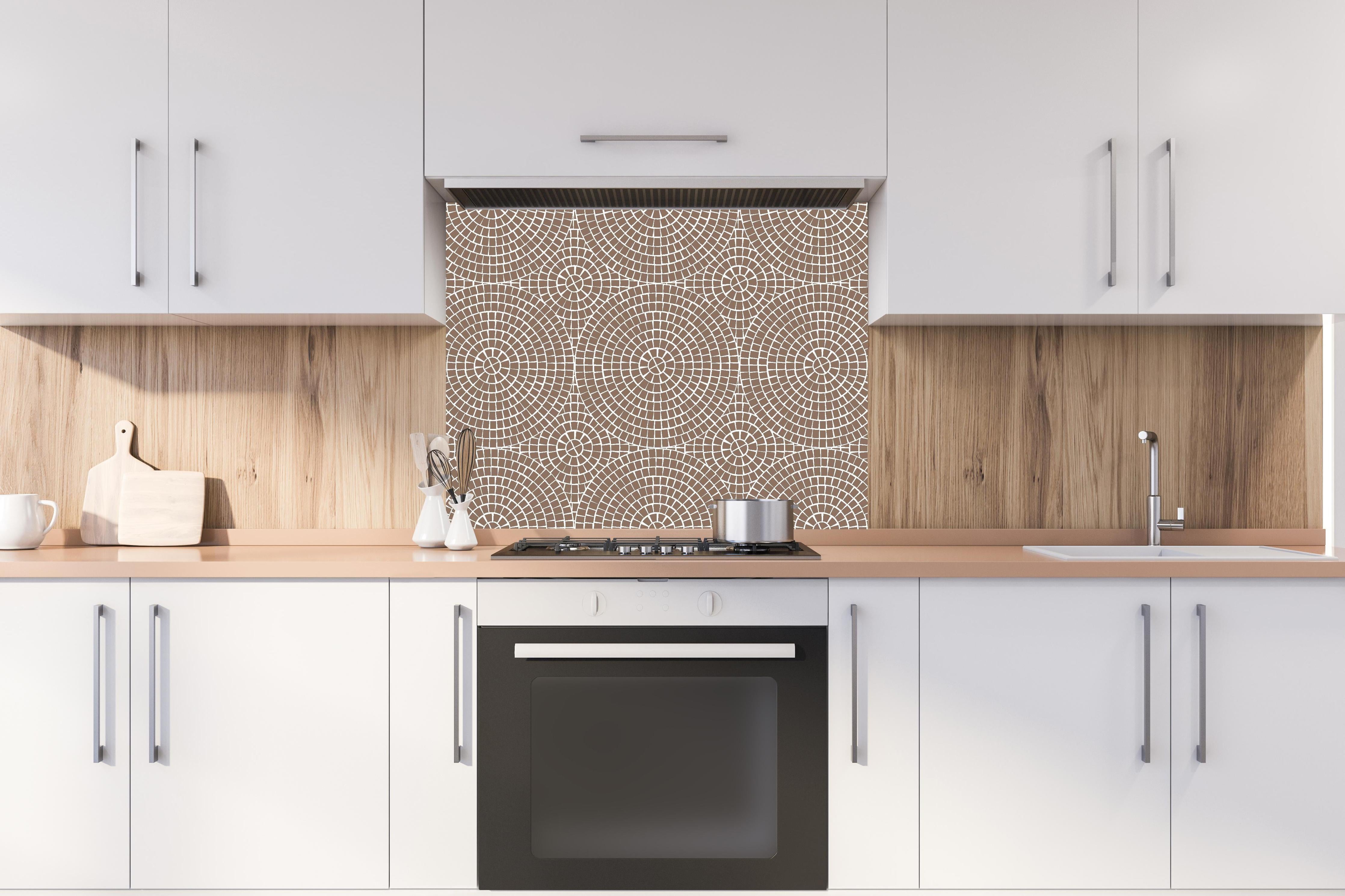 Spritzschutz - Pietre Mosaico Sigaro hinter einem Cerankochfeld zwischen Holz-Kochutensilien