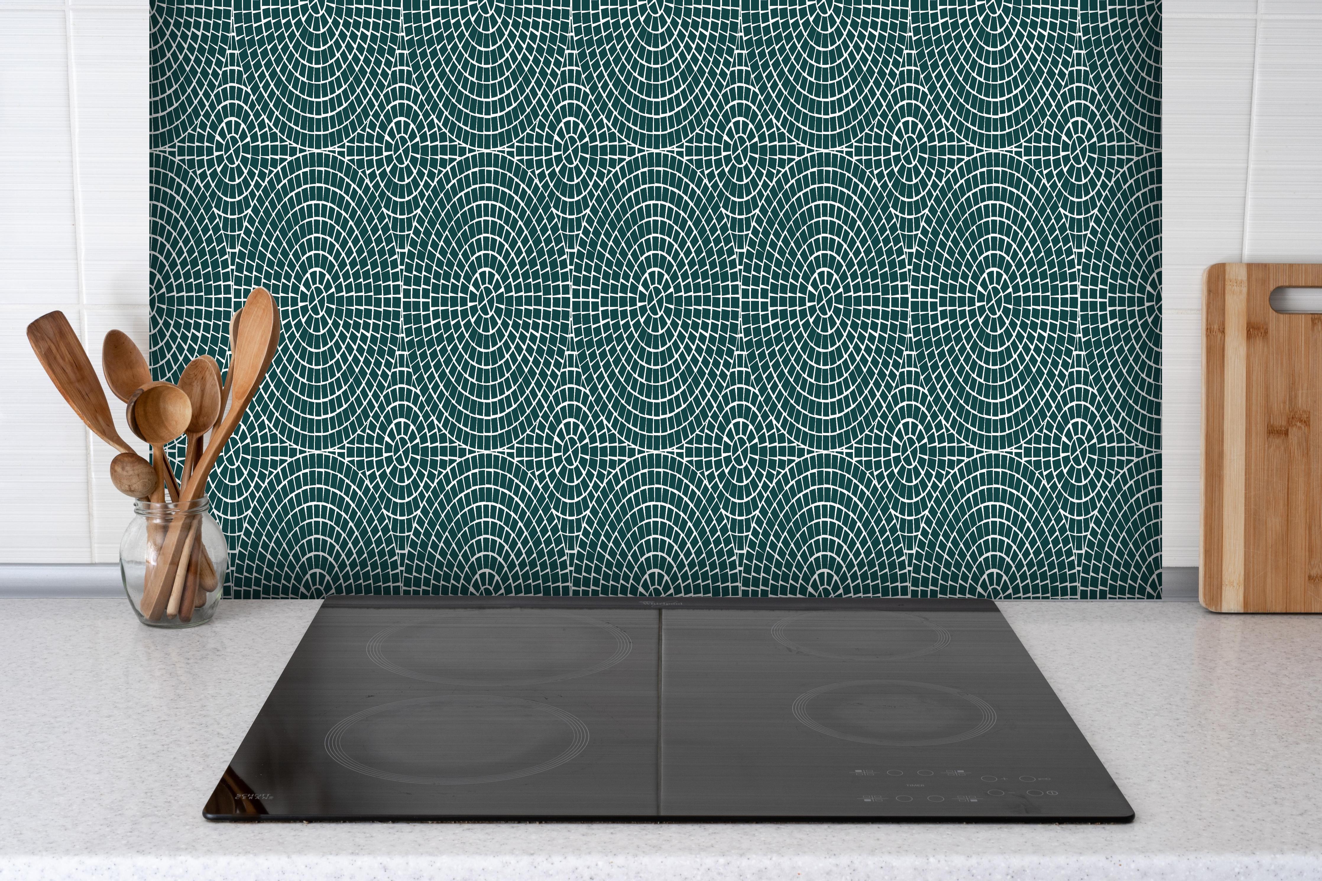 Spritzschutz - Pietre Mosaico Verde petrolio hinter einem Cerankochfeld zwischen Holz-Kochutensilien