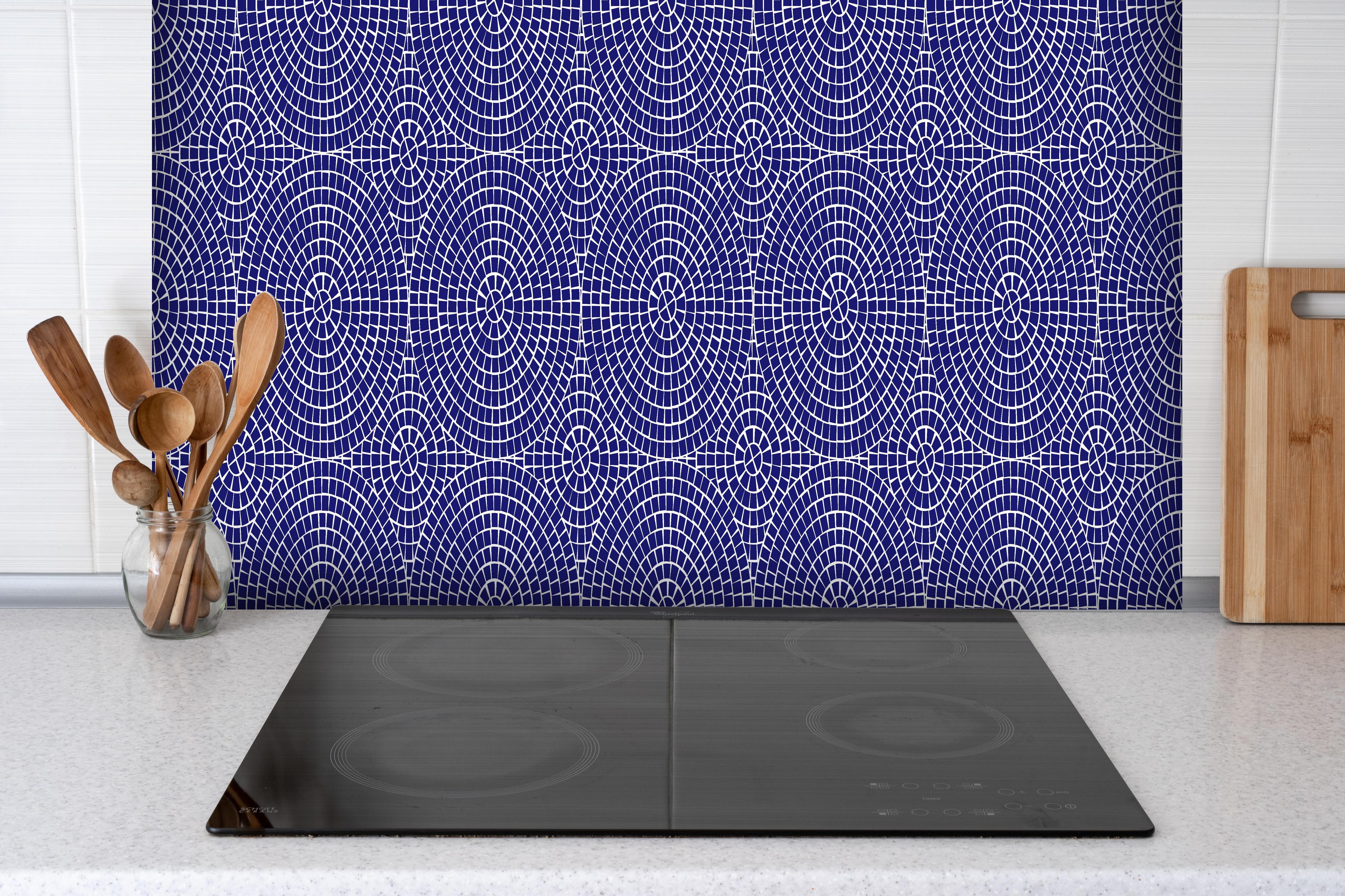 Spritzschutz - Pietre Mosaico Zaffiro hinter einem Cerankochfeld zwischen Holz-Kochutensilien