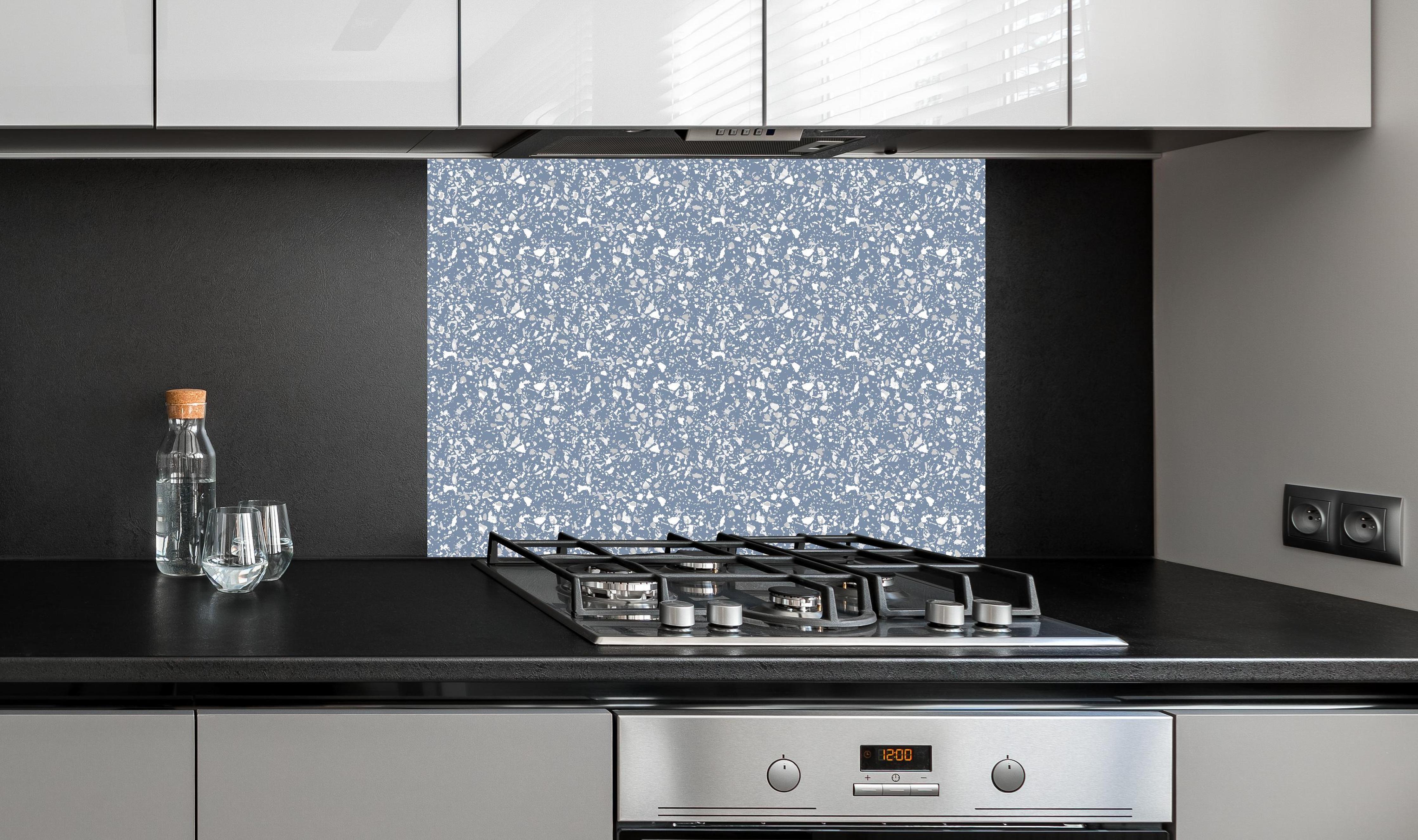 Spritzschutz - Pietre Terrazzo Azzurro polvere hinter einem Cerankochfeld zwischen Holz-Kochutensilien