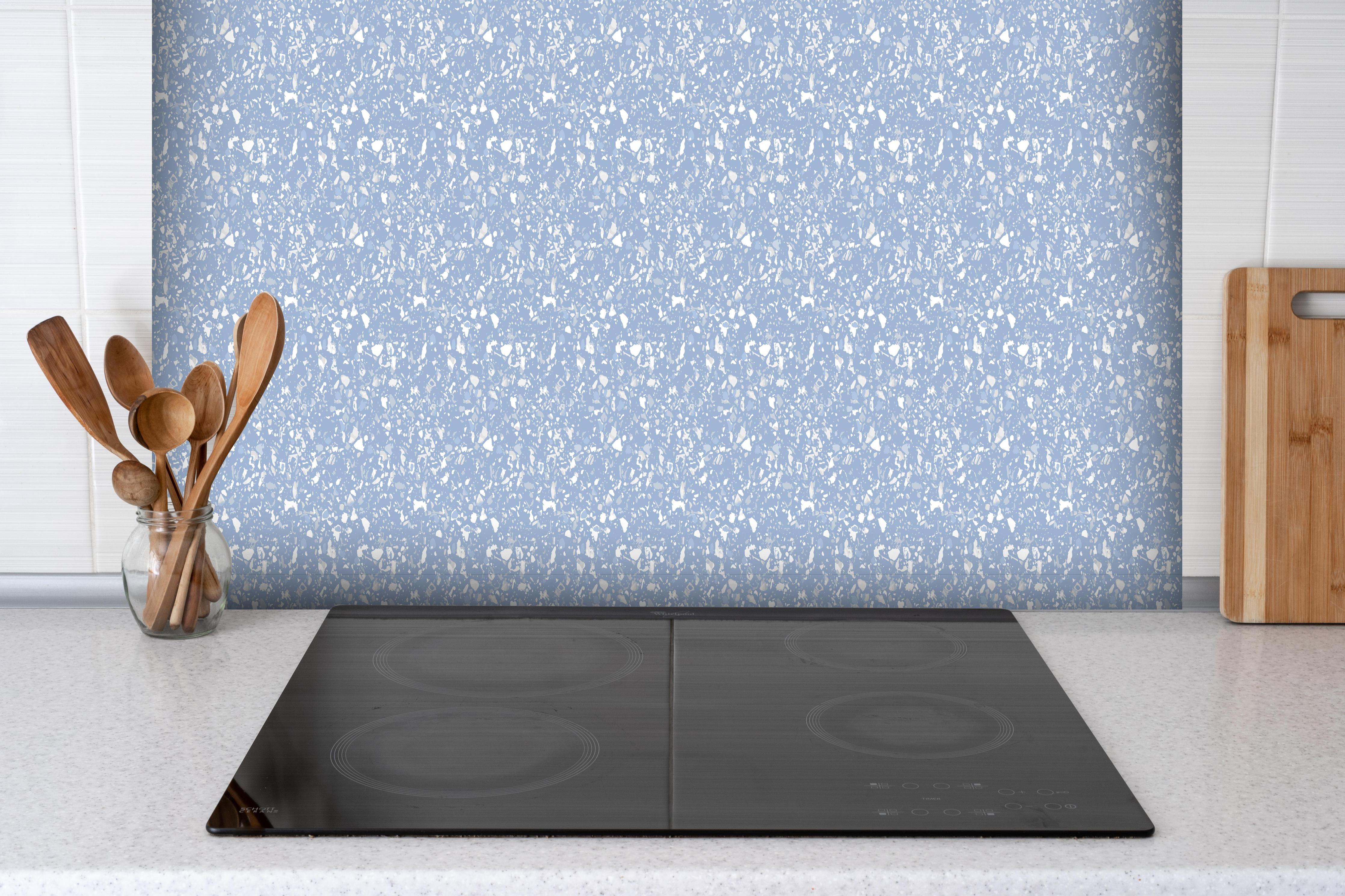 Spritzschutz - Pietre Terrazzo Ceruleo hinter einem Cerankochfeld zwischen Holz-Kochutensilien