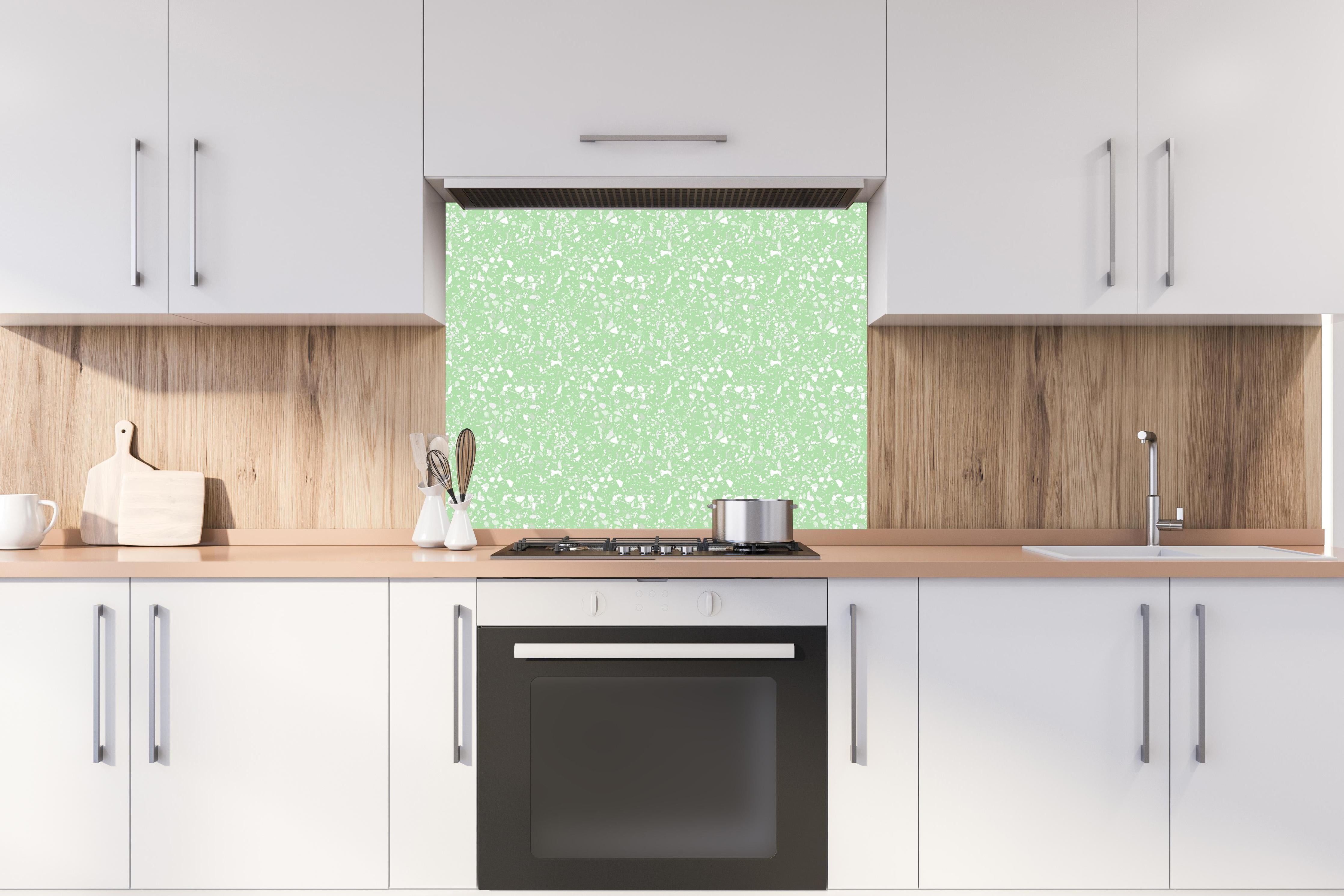 Spritzschutz - Pietre Terrazzo Muschio hinter einem Cerankochfeld zwischen Holz-Kochutensilien