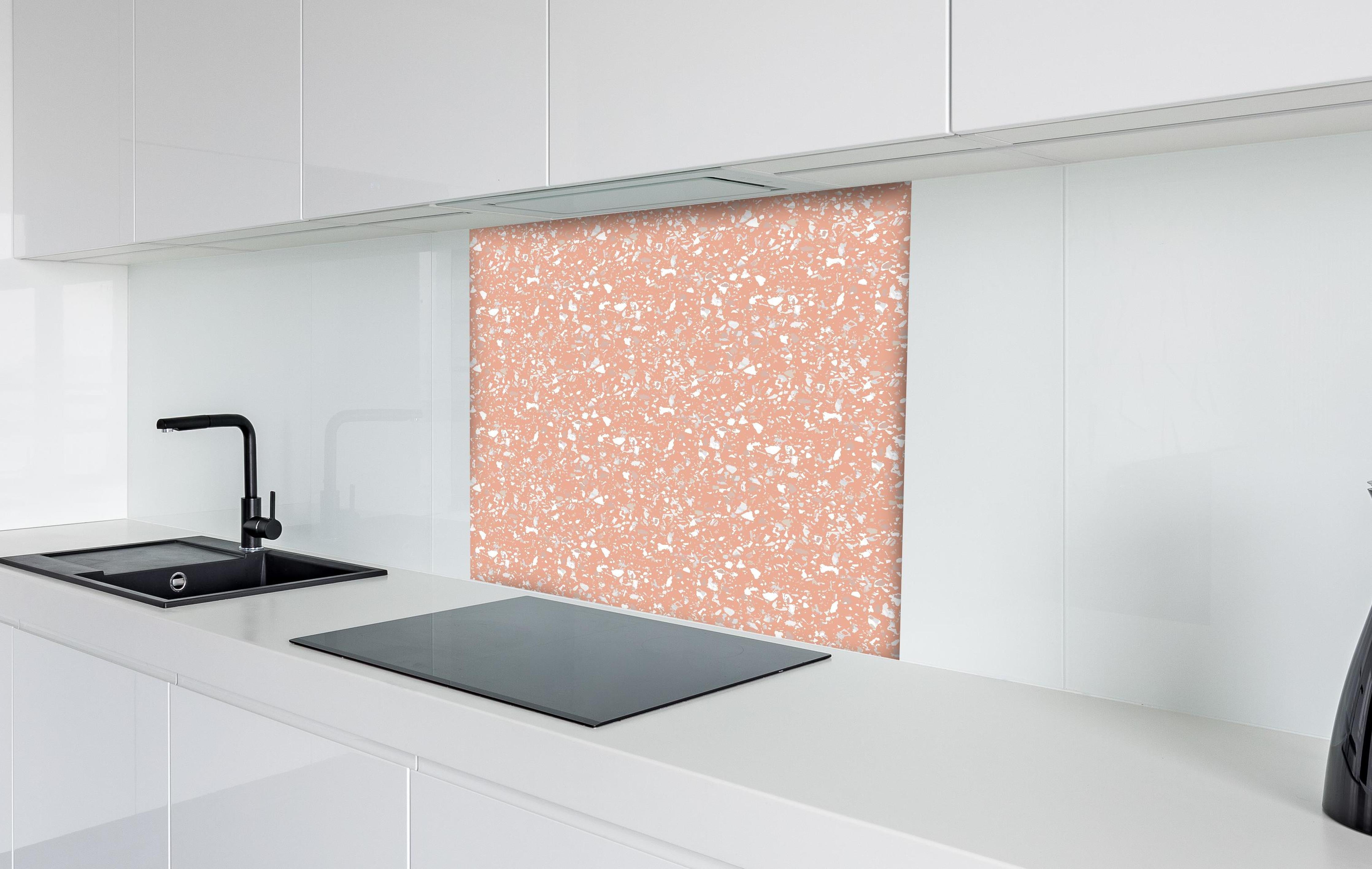 Spritzschutz - Pietre Terrazzo Salmone hinter einem Cerankochfeld zwischen Holz-Kochutensilien