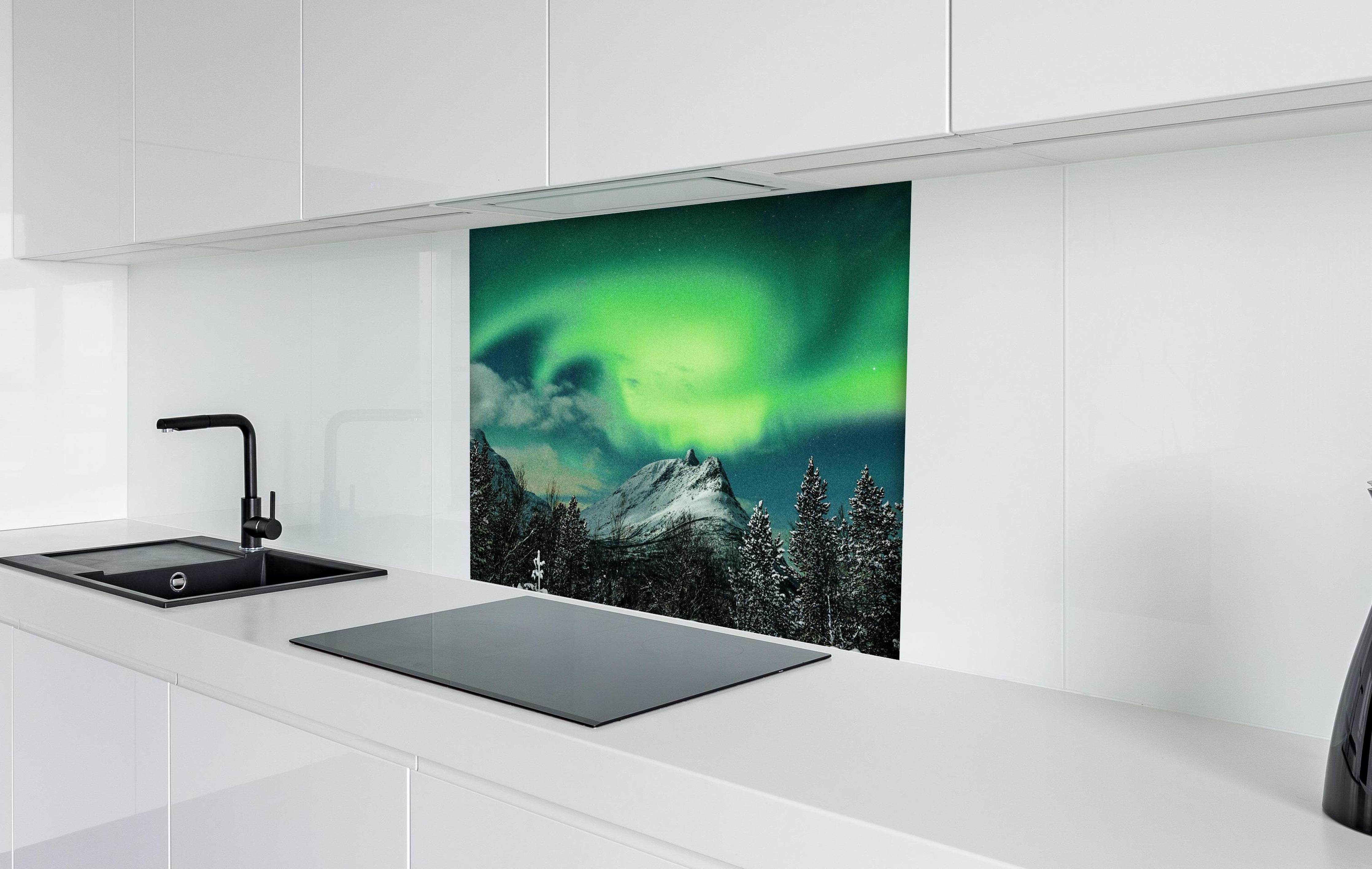 Spritzschutz - Polarlichter über Berg in Nordnorwegen hinter einem Cerankochfeld zwischen Holz-Kochutensilien