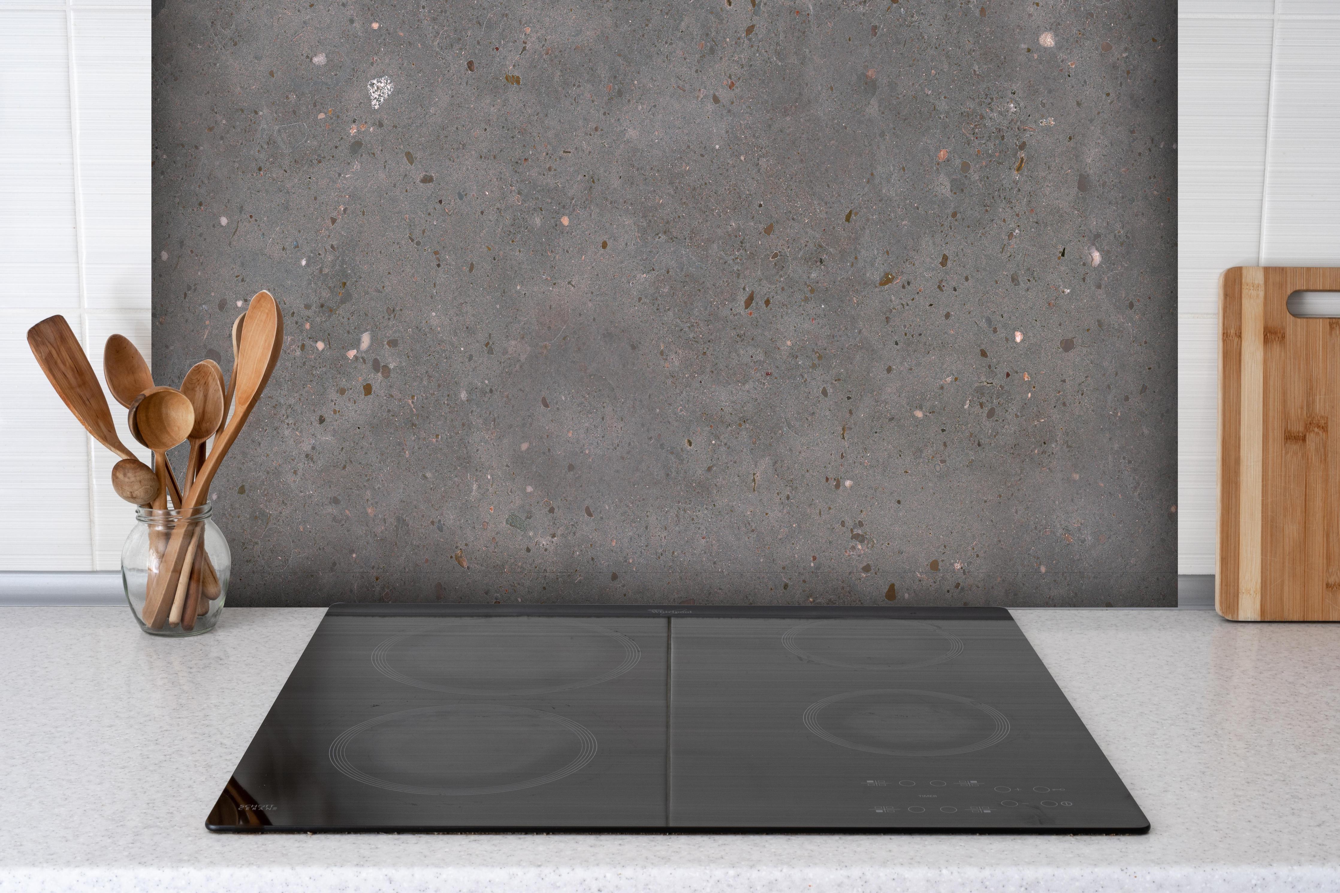 Spritzschutz - Polierter grau-bunter Terrazzoboden Muster hinter einem Cerankochfeld zwischen Holz-Kochutensilien