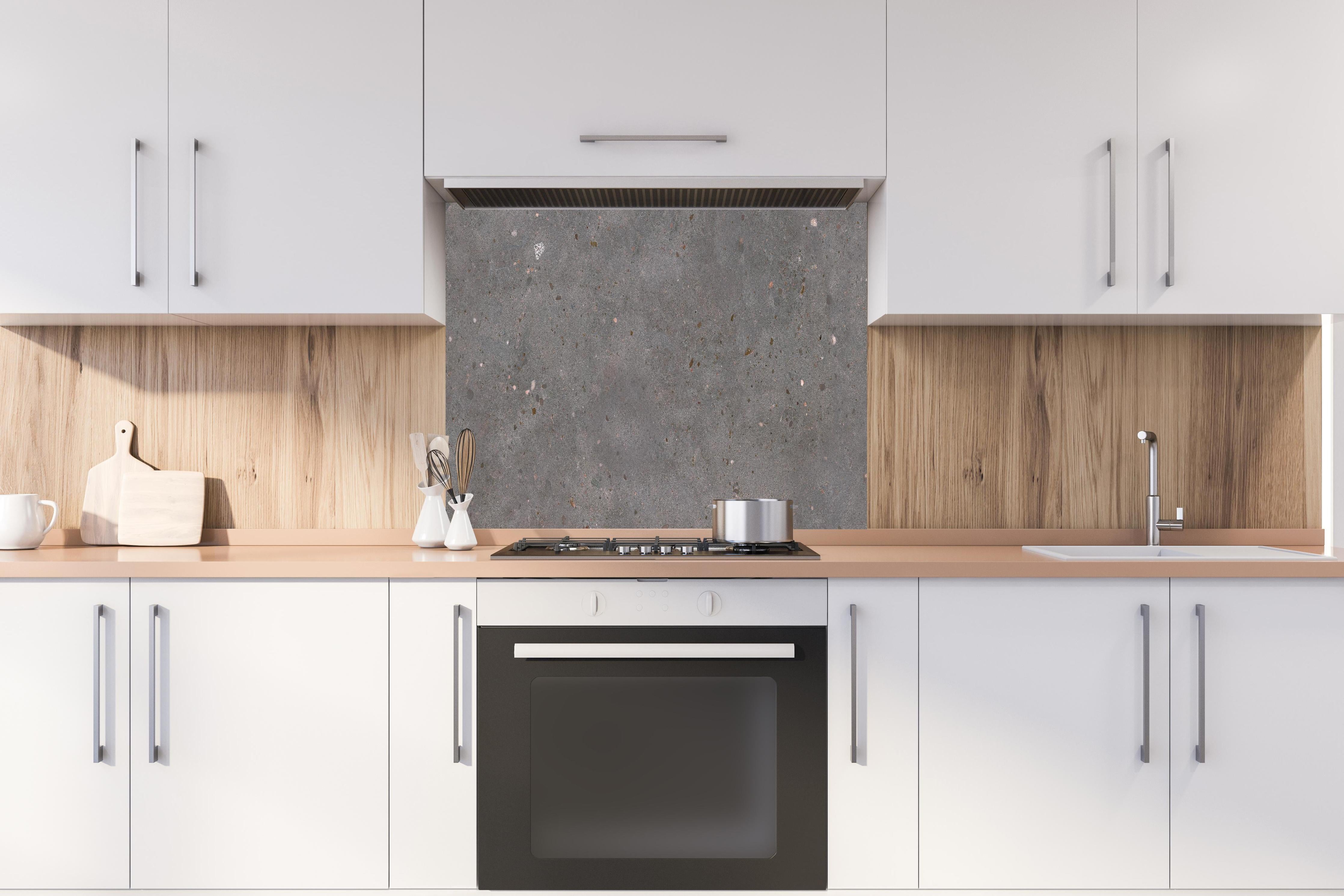 Spritzschutz - Polierter grau-bunter Terrazzoboden Muster hinter einem Cerankochfeld zwischen Holz-Kochutensilien