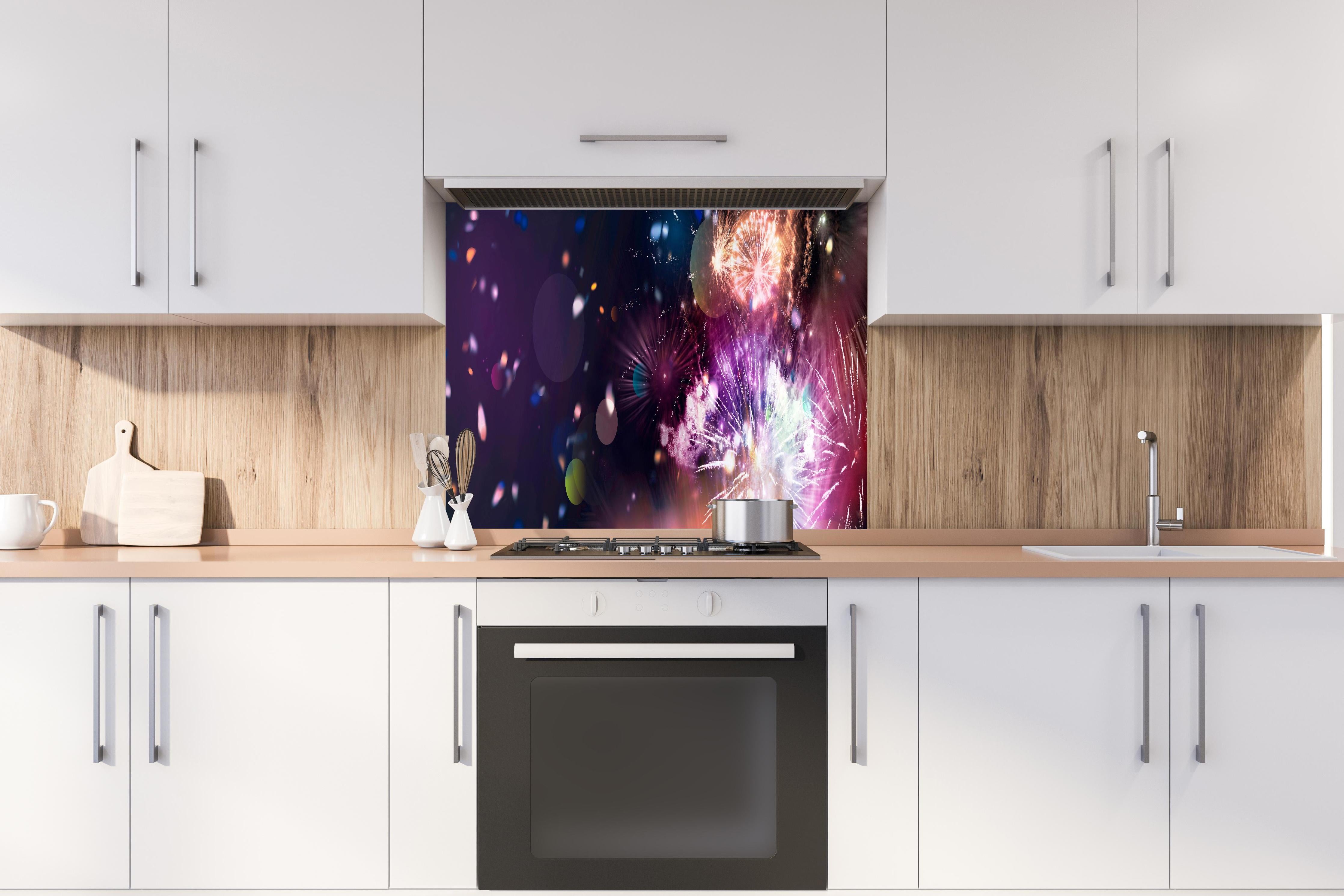 Spritzschutz - Prachtvolles Feuerwerk und schillerndes Konfetti hinter einem Cerankochfeld zwischen Holz-Kochutensilien