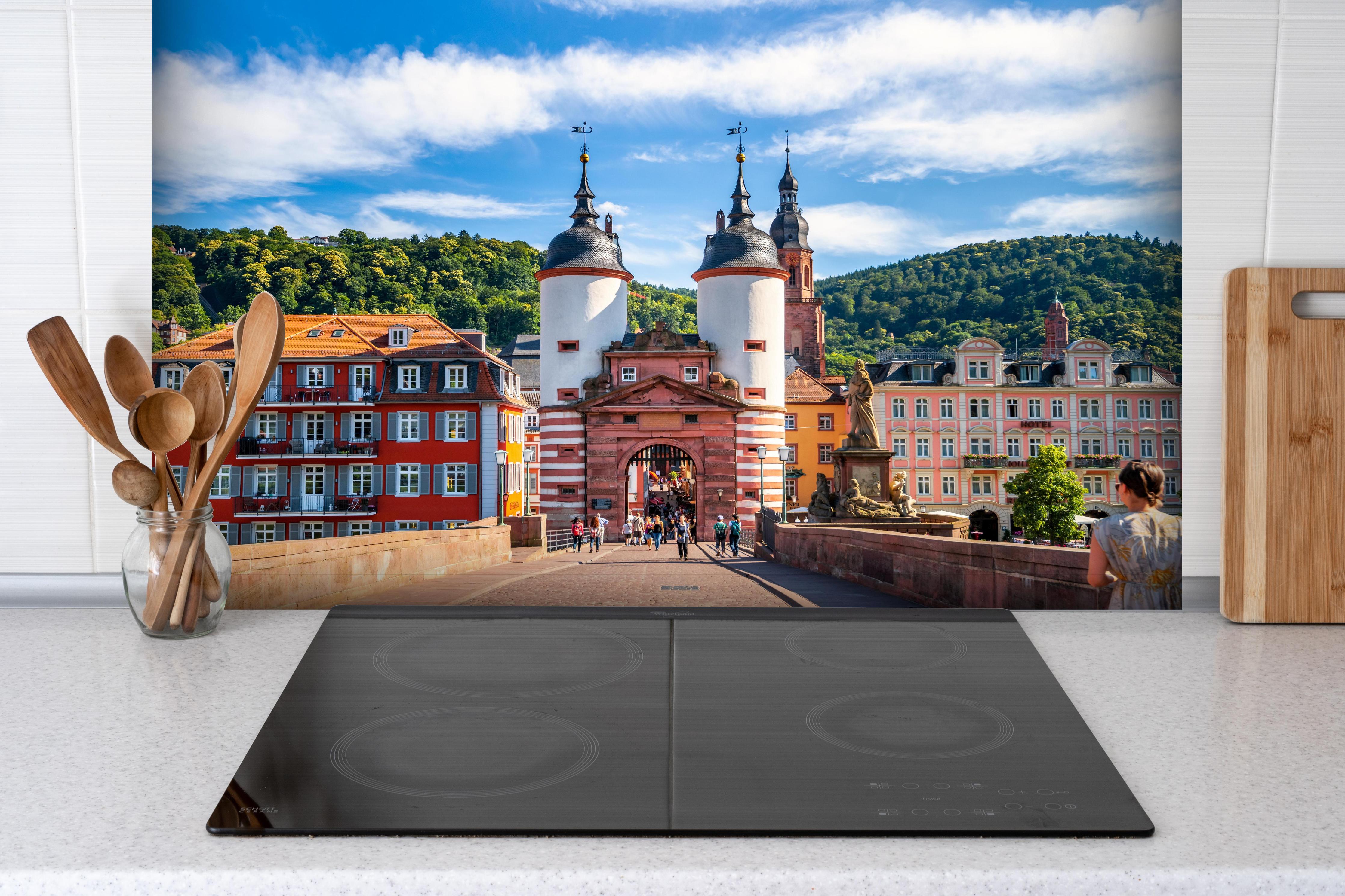Spritzschutz - Prächtiger Anblick auf Brücke in Heidelberg hinter einem Cerankochfeld zwischen Holz-Kochutensilien