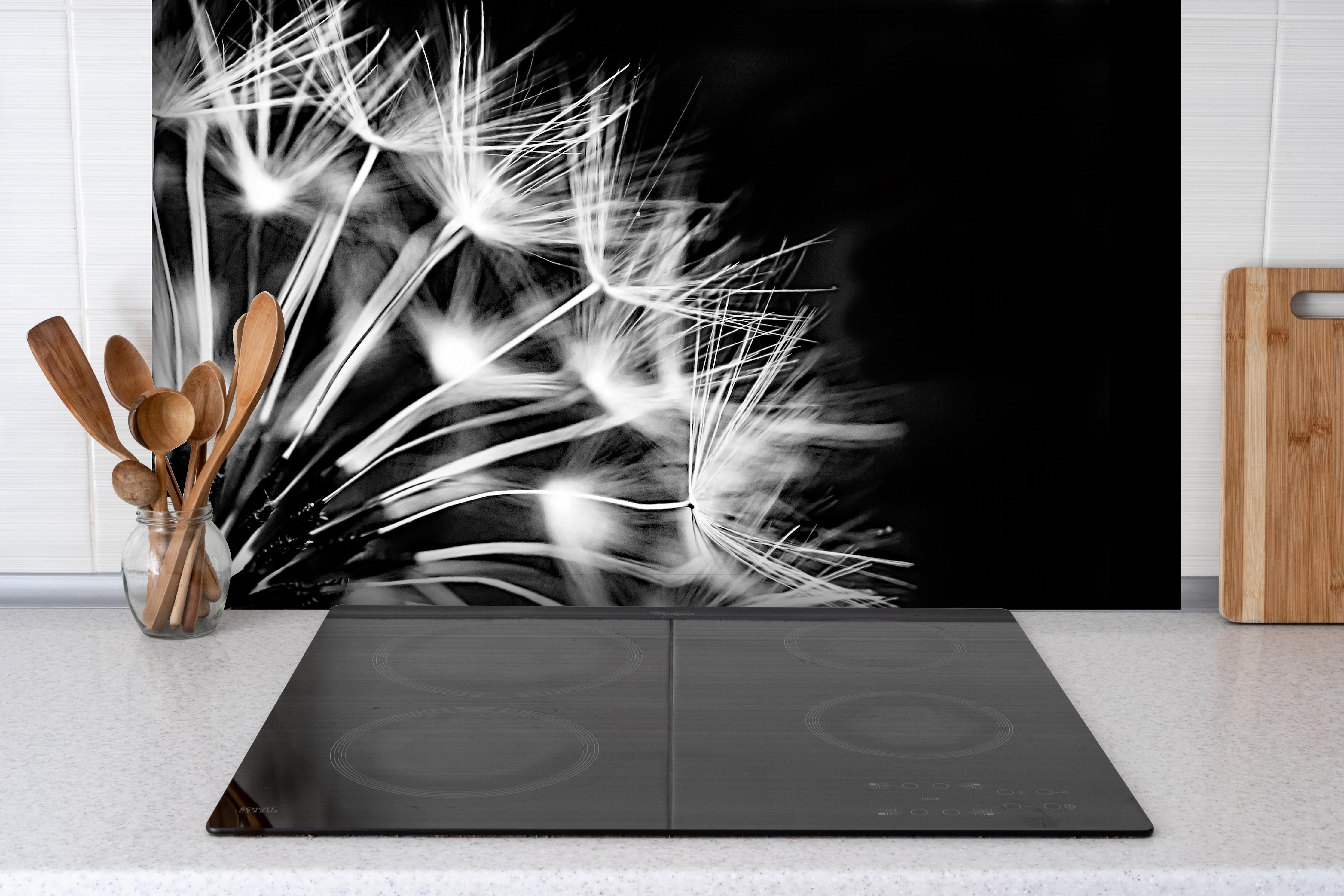 Spritzschutz - Pusteblumen schwarz-weiß Hintergrund hinter einem Cerankochfeld zwischen Holz-Kochutensilien