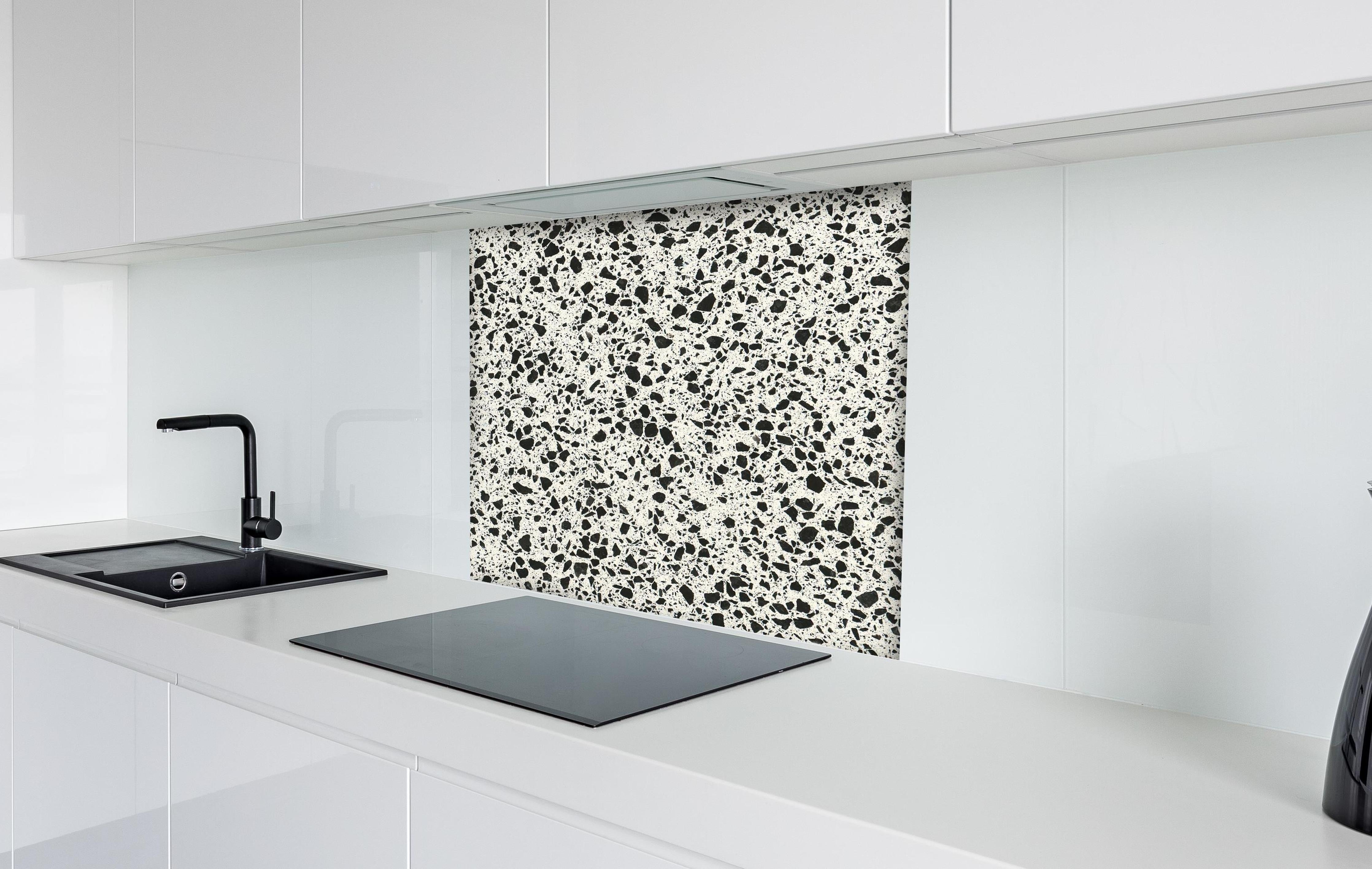 Spritzschutz - Quarz FusionStone White hinter einem Cerankochfeld zwischen Holz-Kochutensilien