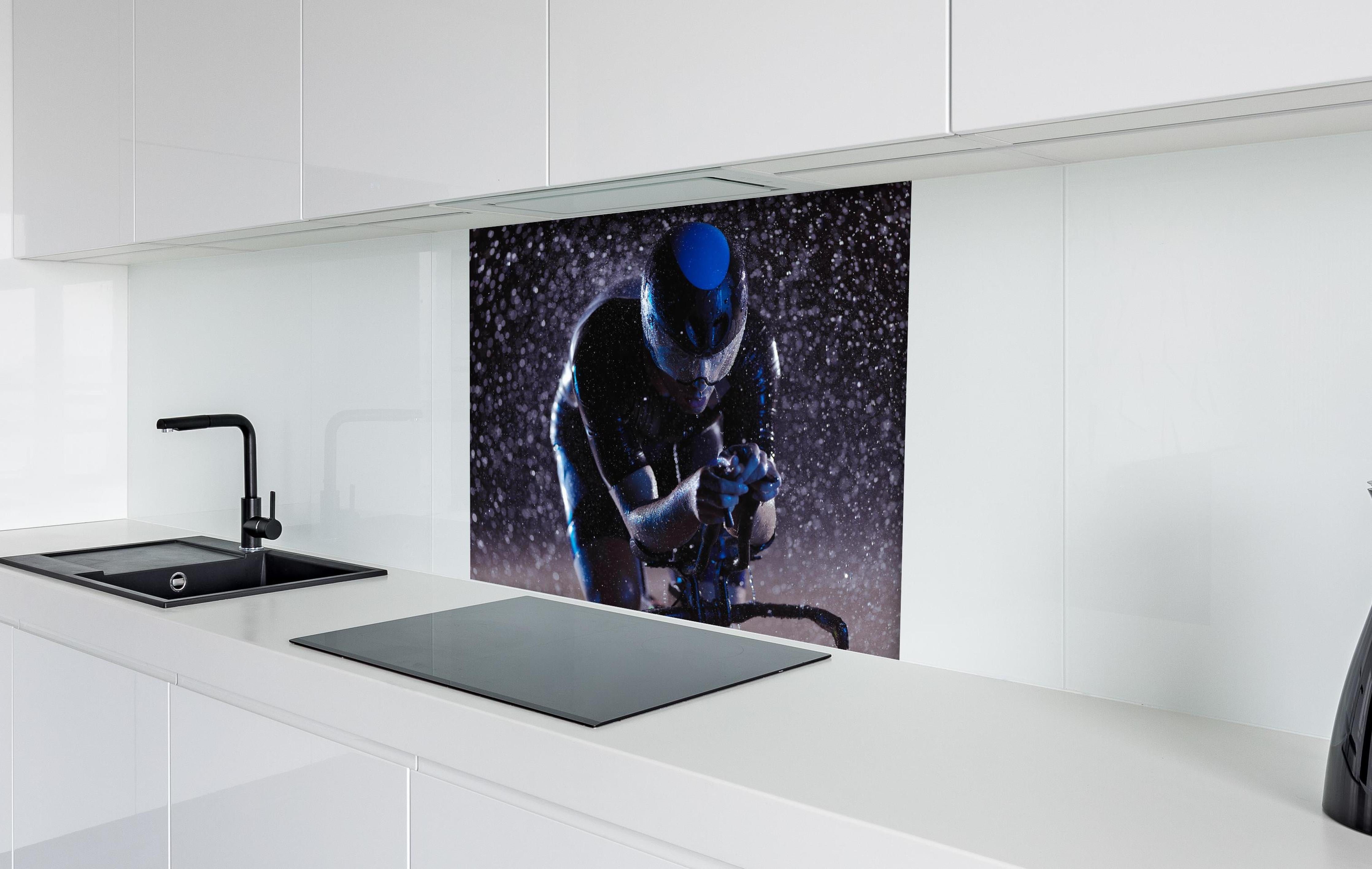 Spritzschutz - Radfahrer nachts bei Regen hinter einem Cerankochfeld zwischen Holz-Kochutensilien