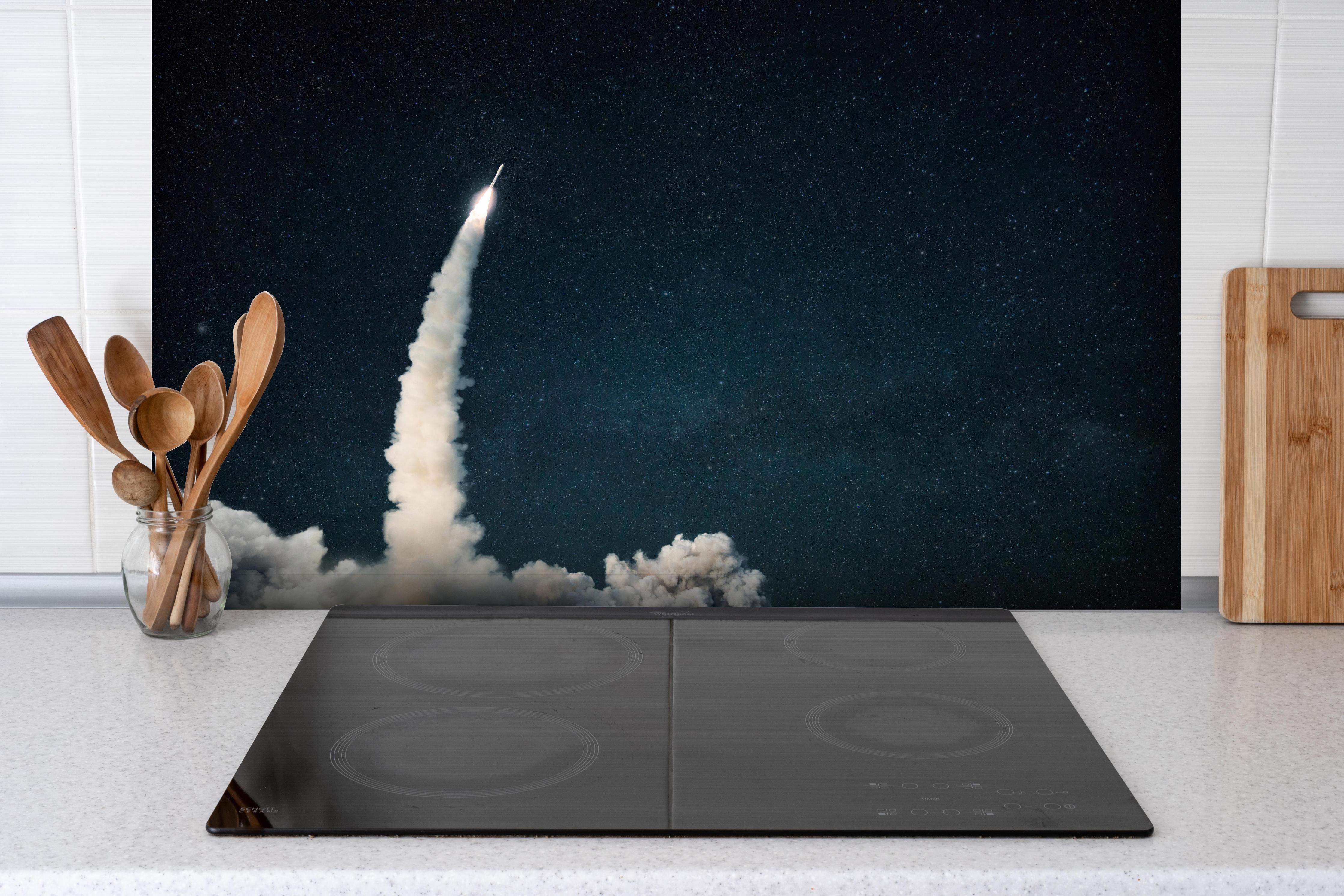 Spritzschutz - Raumschiffstart in den Weltraum hinter einem Cerankochfeld zwischen Holz-Kochutensilien