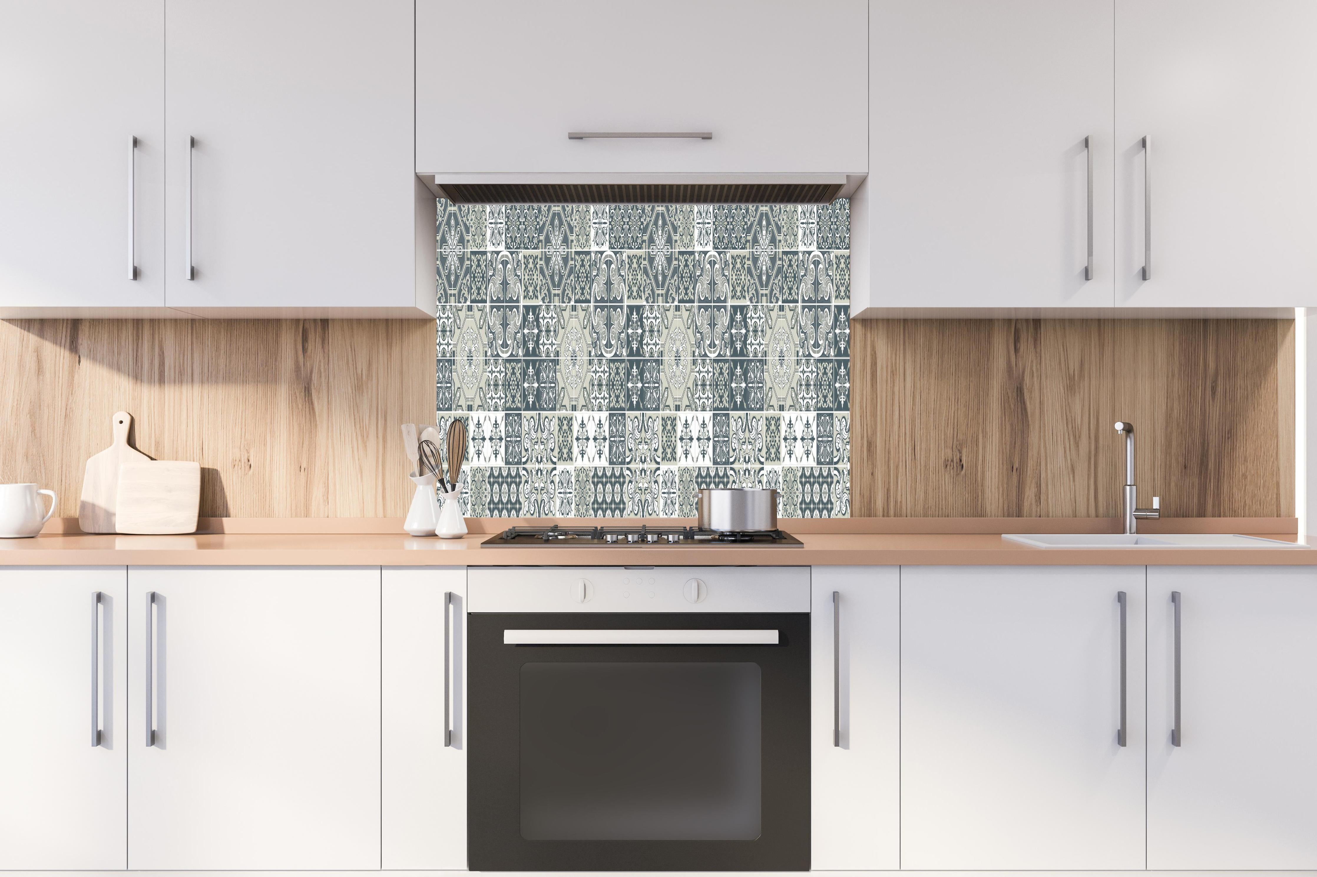 Spritzschutz - Retro Kachel-Dekor in Blau-Weiß-Grau hinter einem Cerankochfeld zwischen Holz-Kochutensilien