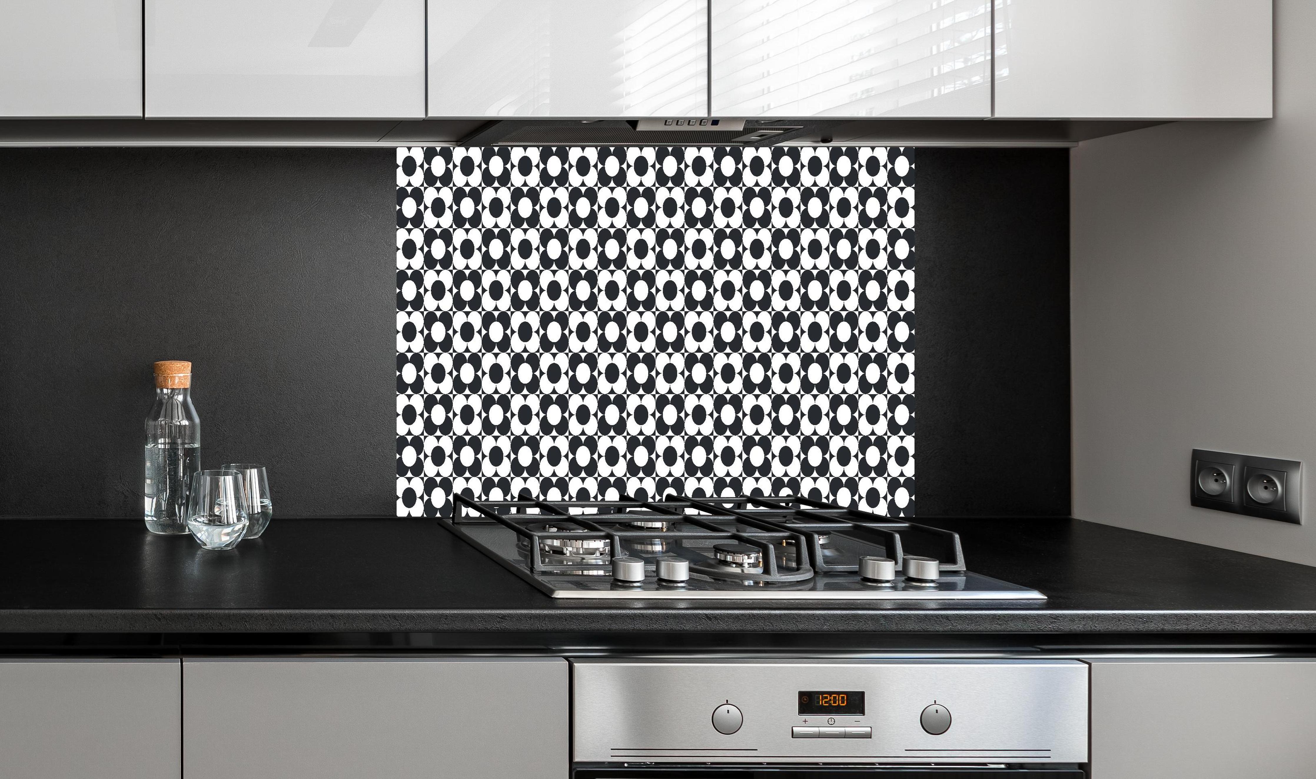 Spritzschutz - Retro Primavera Carbone hinter einem Cerankochfeld zwischen Holz-Kochutensilien