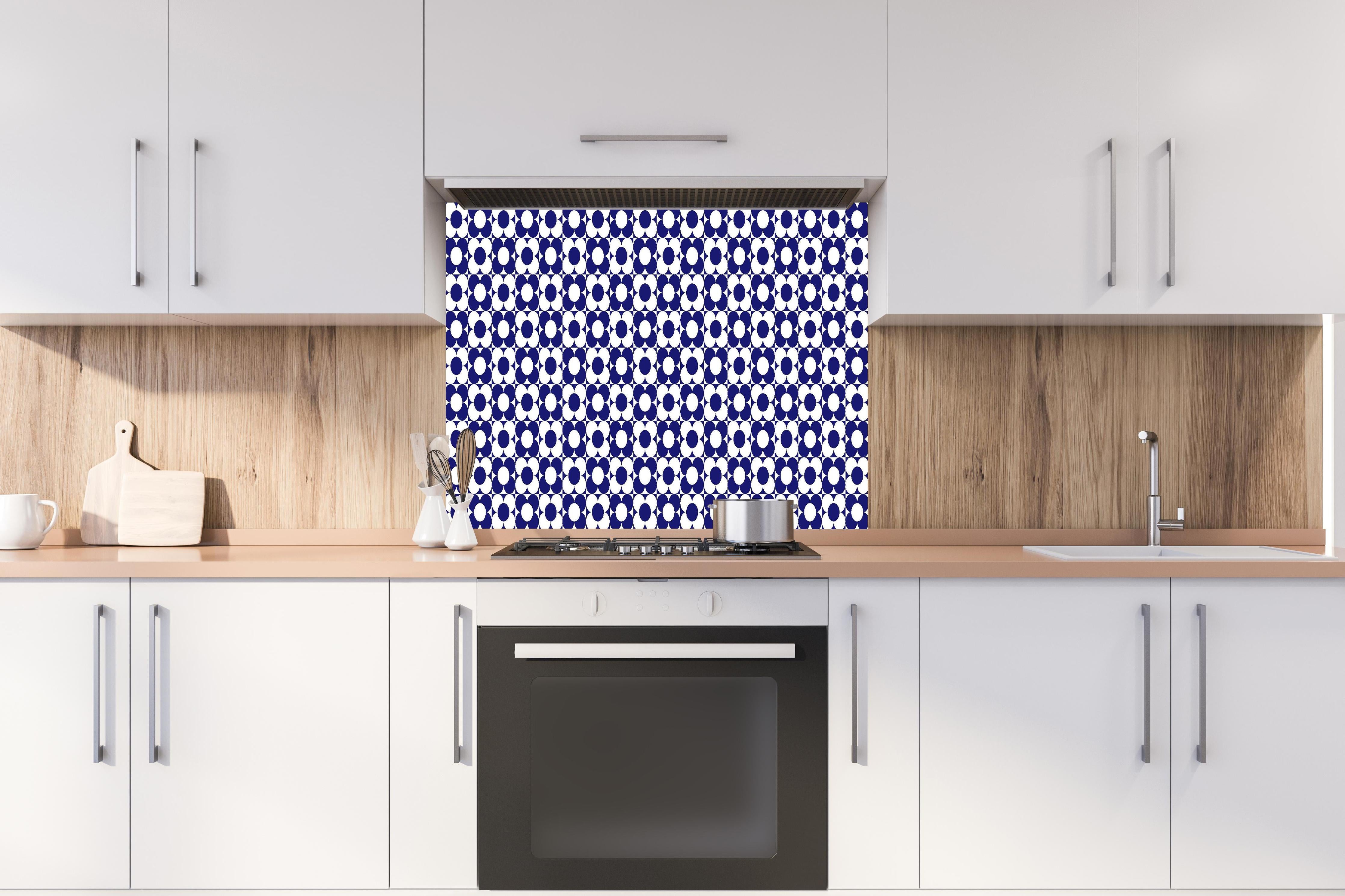 Spritzschutz - Retro Primavera Zaffiro hinter einem Cerankochfeld zwischen Holz-Kochutensilien