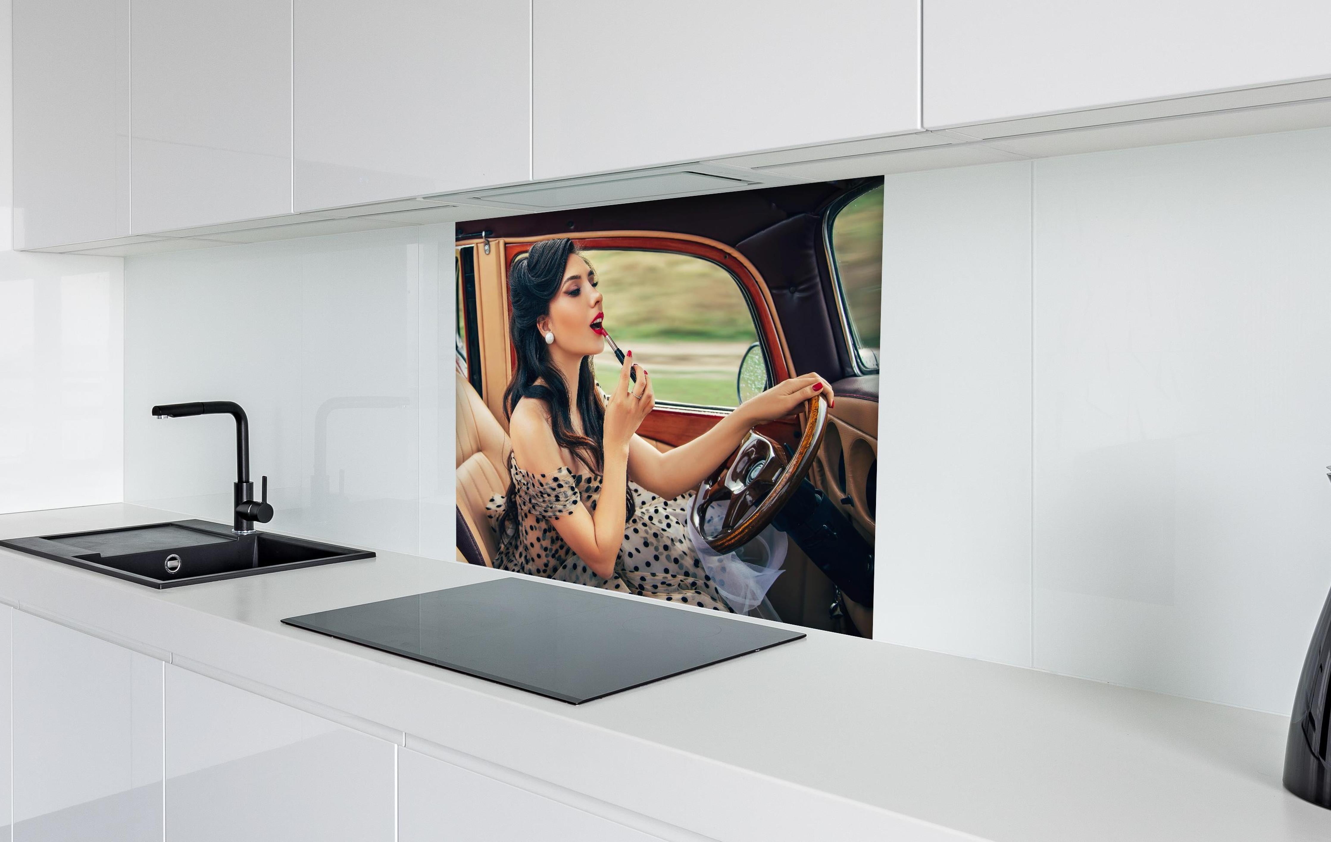 Spritzschutz - Retro Schönheit mit Autolenkrad und Lippenstift hinter einem Cerankochfeld zwischen Holz-Kochutensilien