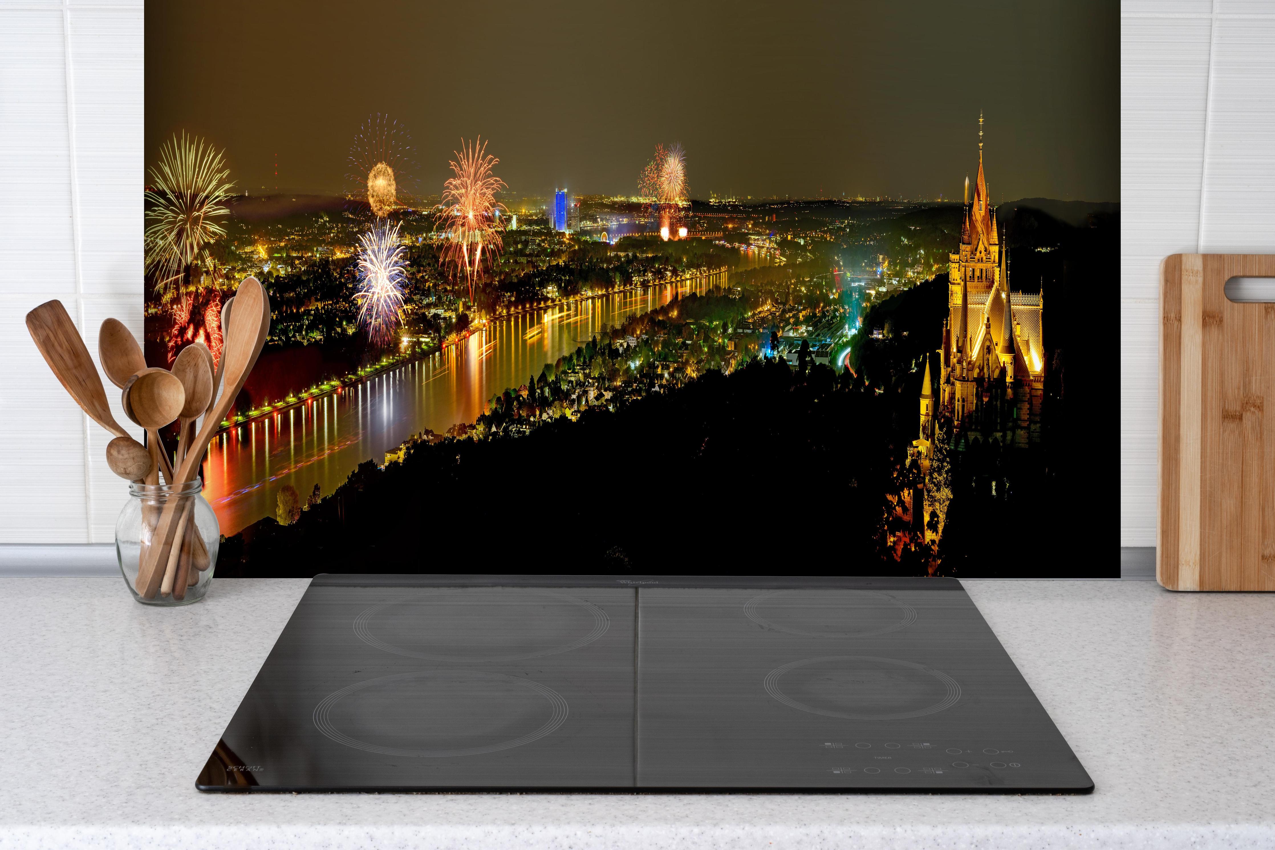 Spritzschutz - Rhein in Flammen hinter einem Cerankochfeld zwischen Holz-Kochutensilien